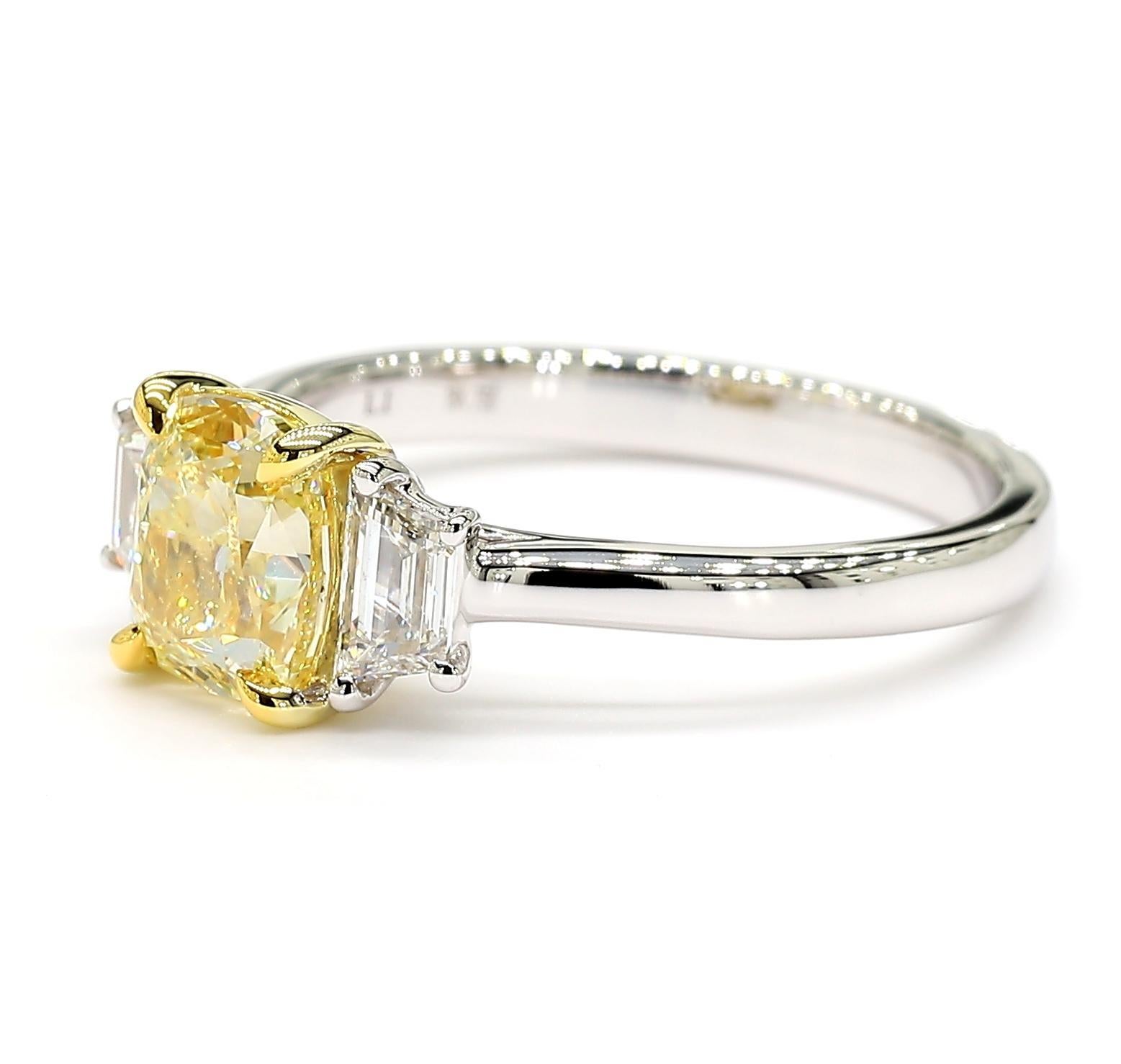La magnifique bague en diamant certifiée GIA de Raregemworld. Monté dans une belle monture en or jaune et blanc 18 carats avec un diamant jaune naturel de taille coussin. Le diamant jaune est entouré de diamants blancs de taille trapézoïdale