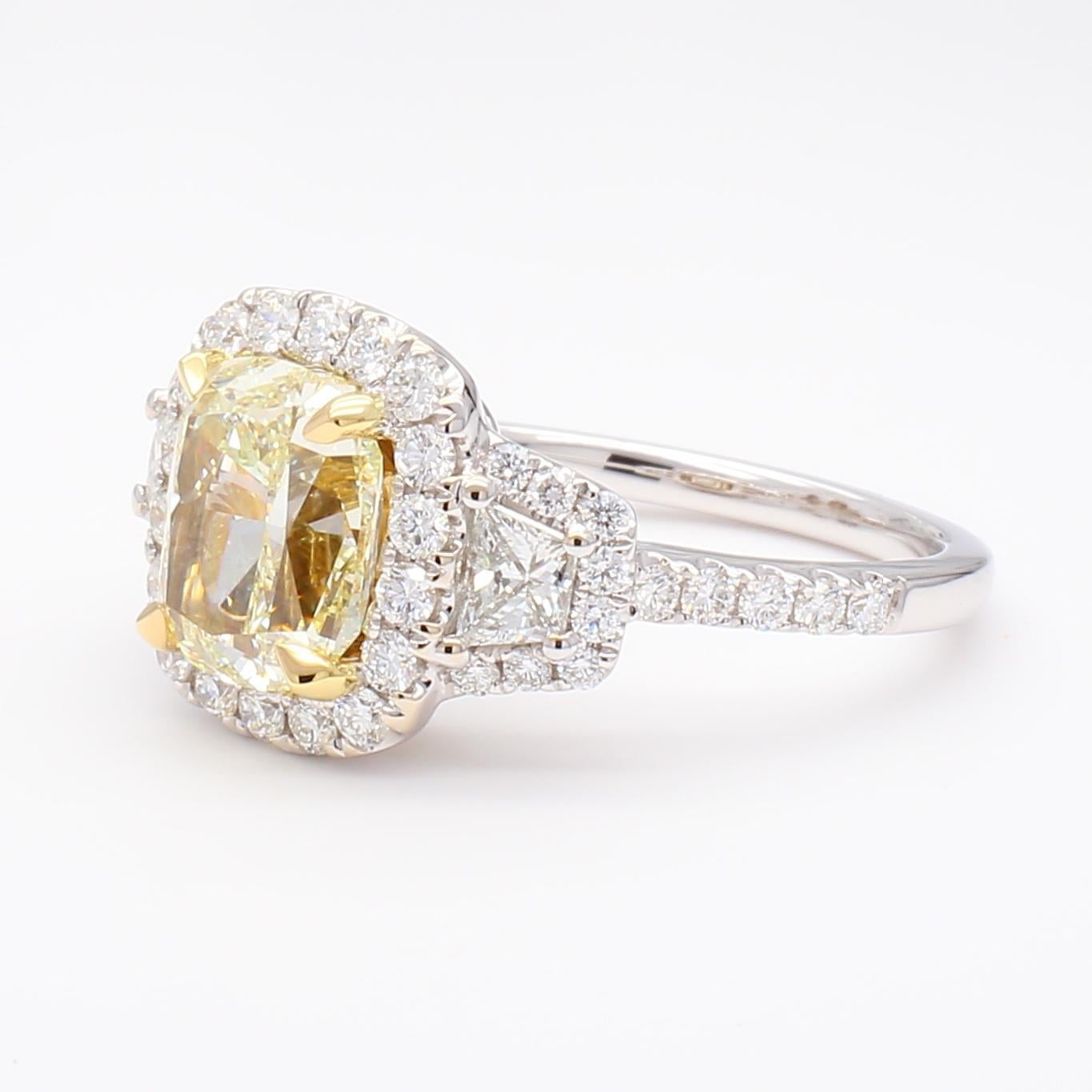 Precioso anillo de cóctel de diamantes con certificado GIA de RareGemWorld. Montada en un precioso engaste de oro amarillo y blanco de 18 quilates con un diamante amarillo natural de talla cojín. El diamante amarillo está rodeado de diamantes