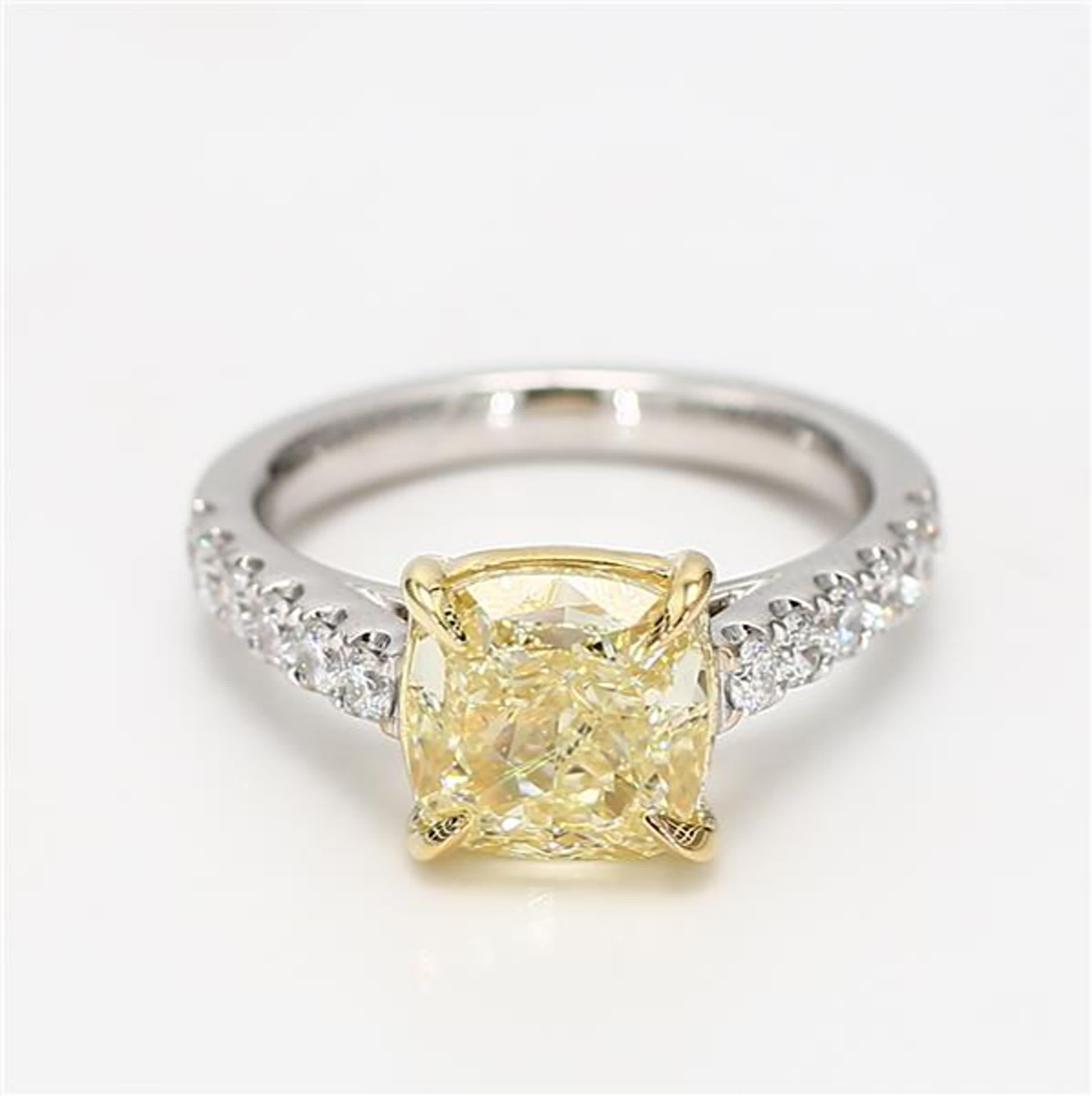 La bague classique en diamant certifiée GIA de Raregemworld. Monté dans une belle monture en or jaune et blanc 18 carats avec un diamant jaune naturel de taille coussin. Le diamant jaune est entouré d'une mêlée de diamants blancs ronds naturels.