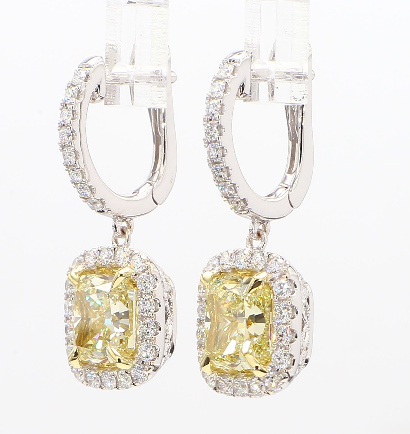 RareGemWorld's beautiful GIA certified diamond earrings. Mounted in a beautiful 18K Yellow and White Gold setting with natural cushion cut yellow diamonds. The yellow diamonds are surrounded by round natural white diamond melee. These earrings are