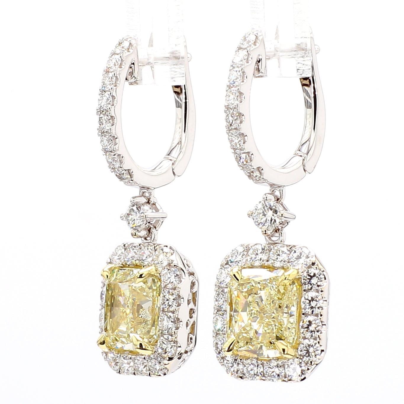 RareGemWorld's beautiful GIA certified diamond earrings. Mounted in a beautiful 18K Yellow and White Gold setting with natural cushion cut yellow diamonds. The yellow diamonds are surrounded by round natural white diamond melee. These earrings are