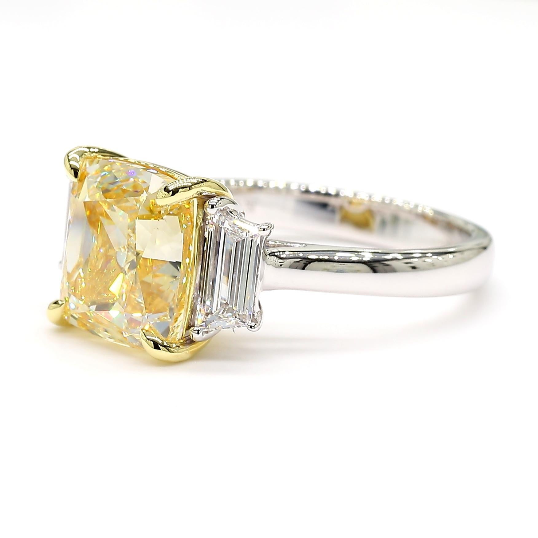 RareGemWorld's beautiful GIA certified diamond ring. Mounted in a beautiful 18K Yellow and White Gold setting with a natural cushion cut yellow diamond. The yellow diamond is surrounded by natural trapezoid cut white diamonds. This ring is