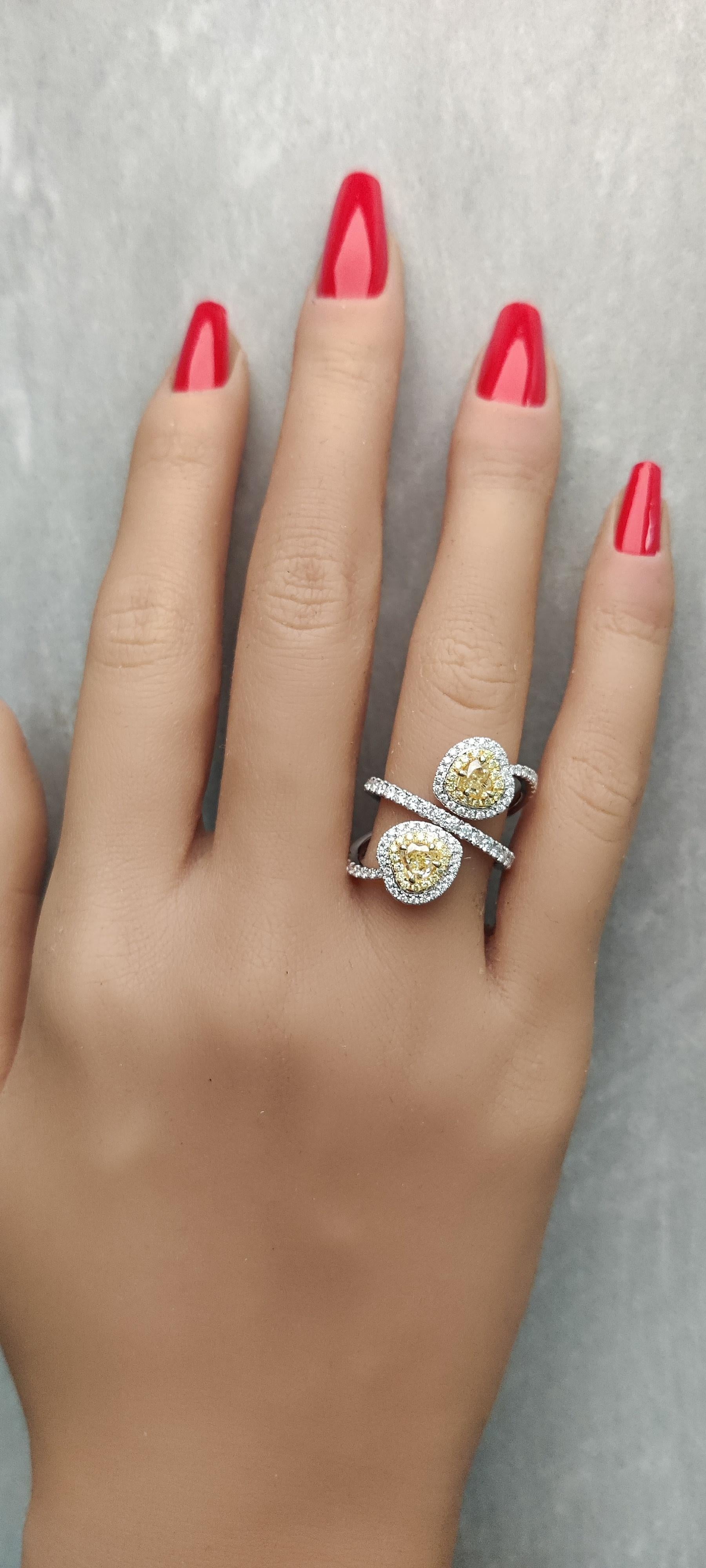 RareGemWorld's classic GIA certified diamond ring. Mounted in a beautiful 18K Yellow and White setting with two natural heart cut yellow diamonds. The yellow diamonds are surrounded by round natural white diamond melee and round natural yellow