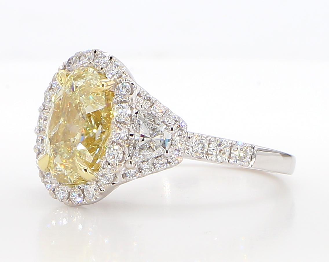 RareGemWorld's classic GIA certified diamond ring. Mounted in a beautiful 18K Yellow and White Gold setting with a natural oval cut yellow diamond. The yellow diamond is surrounded by natural trapezoid cut white diamond and round natural white