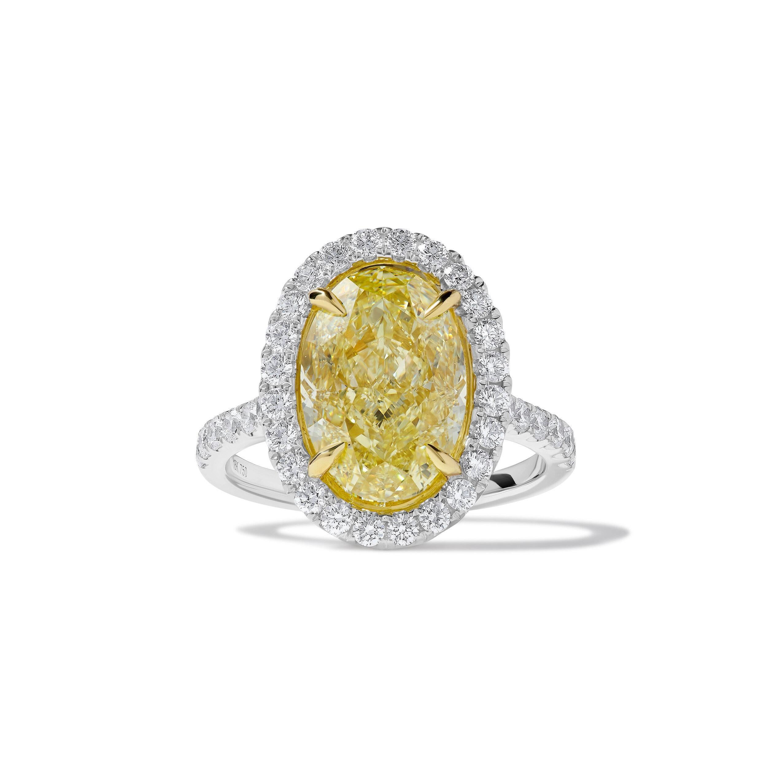 Precioso anillo de diamantes con certificado GIA de RareGemWorld. Montada en un precioso engaste de oro amarillo y blanco de 18 quilates con un diamante amarillo natural de talla oval. El diamante amarillo está rodeado de melee diamante blanco