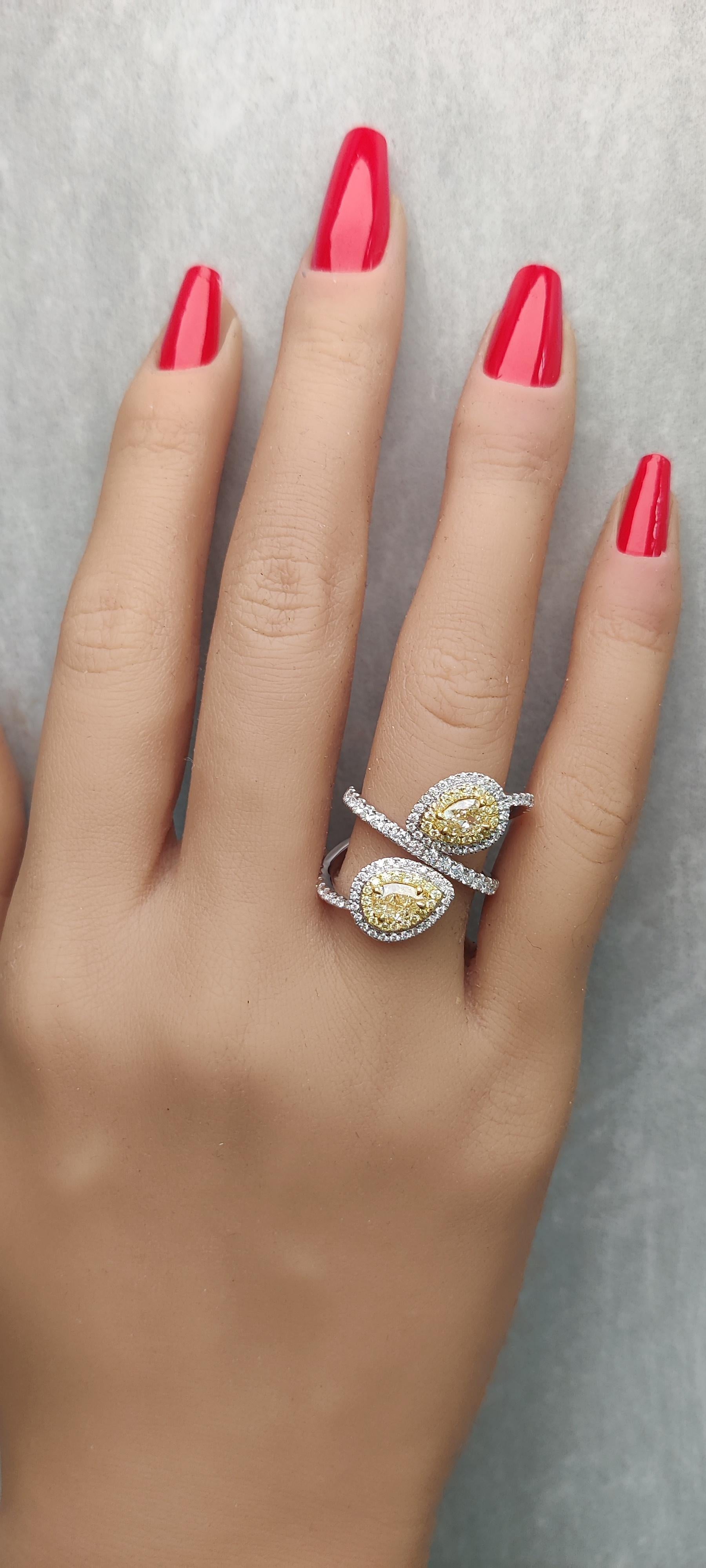 RareGemWorld's classic GIA certified diamond ring. Mounted in a beautiful 18K Yellow and White setting with two natural pear cut yellow diamonds. The yellow diamonds are surrounded by round natural white diamond melee and round natural yellow