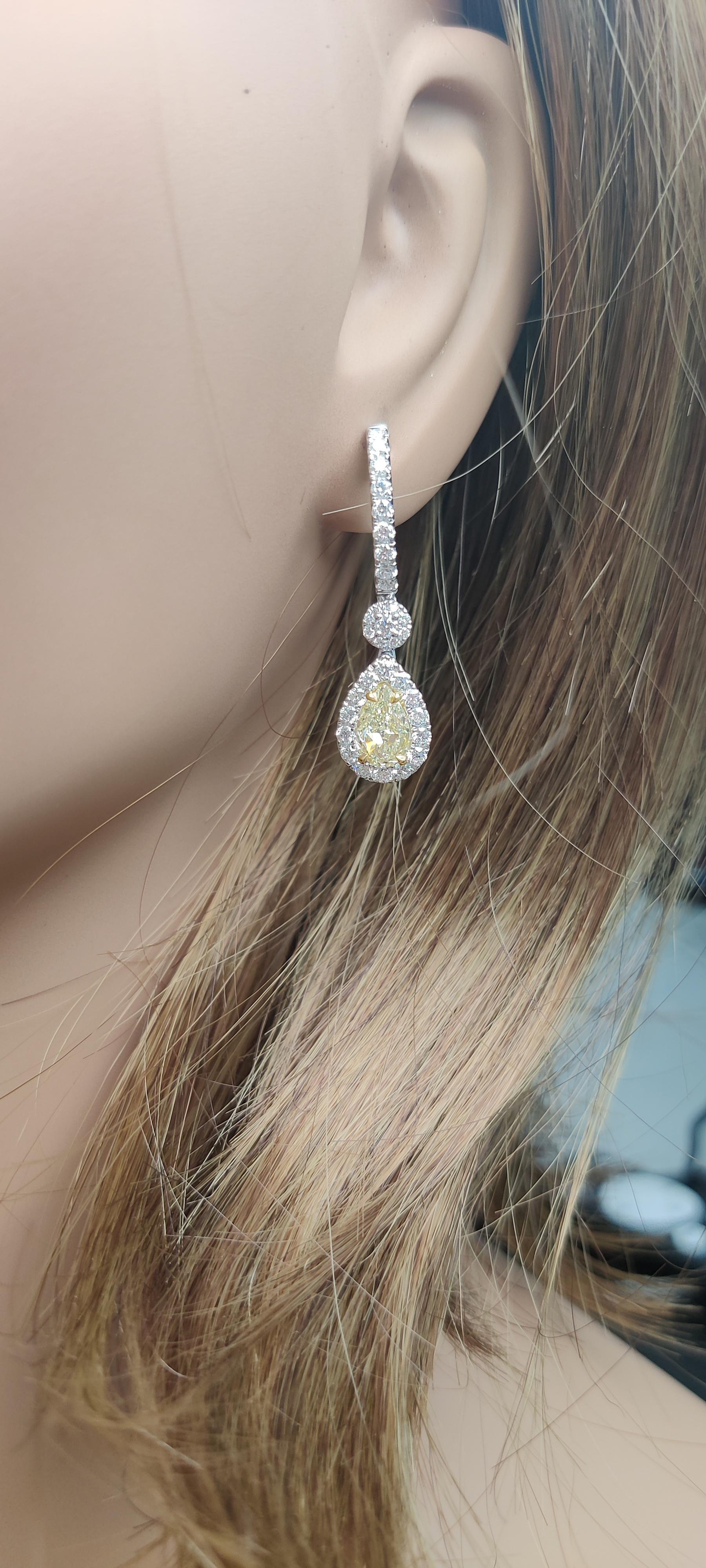Les boucles d'oreilles classiques en diamant de Raregemworld. Monté dans une belle monture en or jaune et blanc 18 carats avec des diamants jaunes naturels de taille poire. Les diamants jaunes sont entourés d'une mêlée de diamants blancs ronds