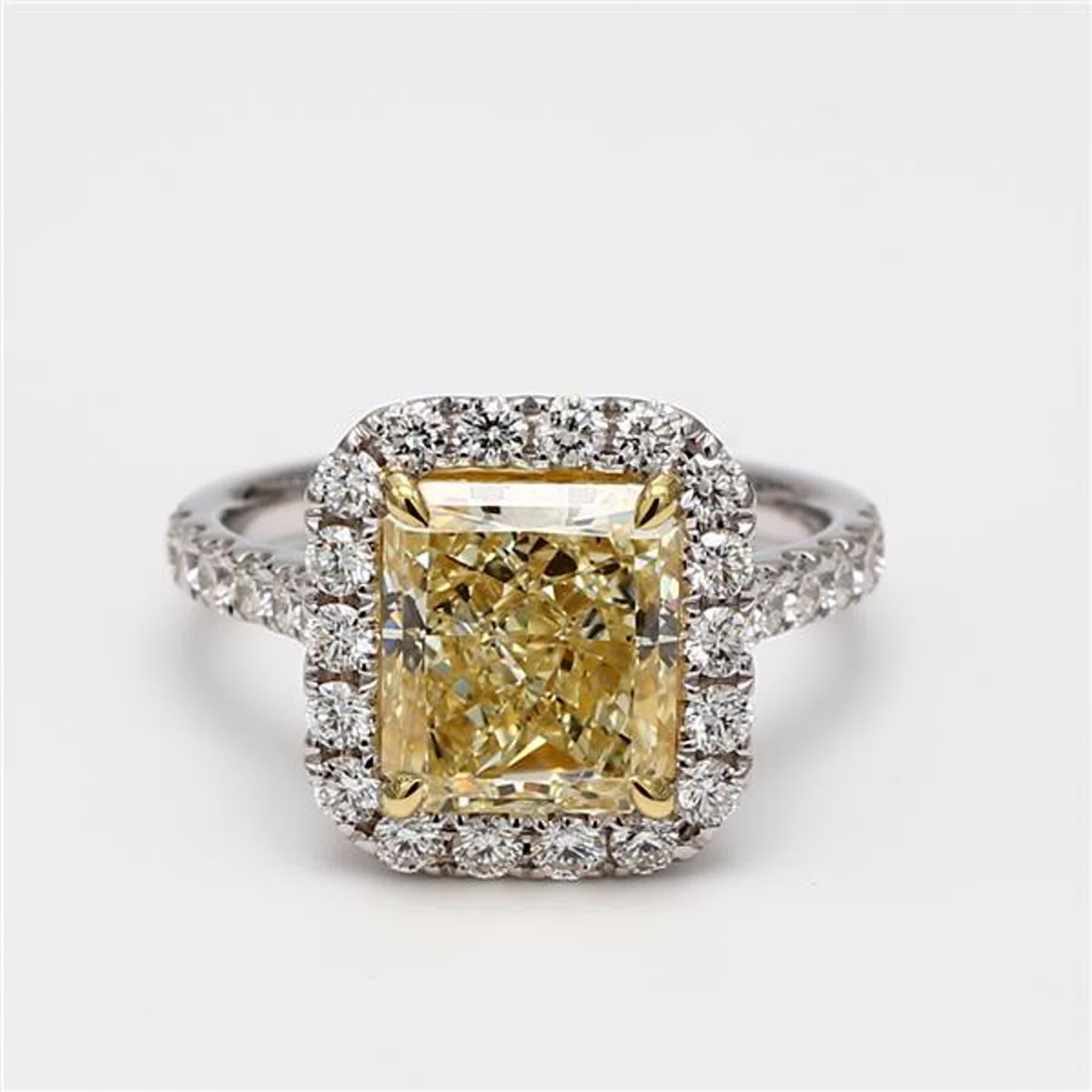RareGemWorld's classic diamond ring. Mounted in a beautiful 18K Yellow and White Gold setting with a natural radiant cut yellow diamond. The yellow diamond is surrounded by round natural white diamond melee. This ring is guaranteed to impress and