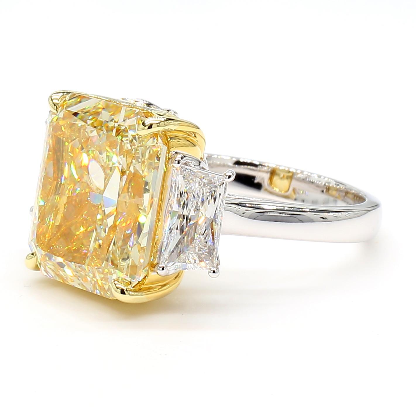 La magnifique bague en diamant de Raregemworld. Monté dans une belle monture en or jaune et blanc 18 carats avec un diamant jaune naturel de taille radieuse. Le diamant jaune est entouré de deux diamants blancs de taille trapézoïdale certifiés GIA.
