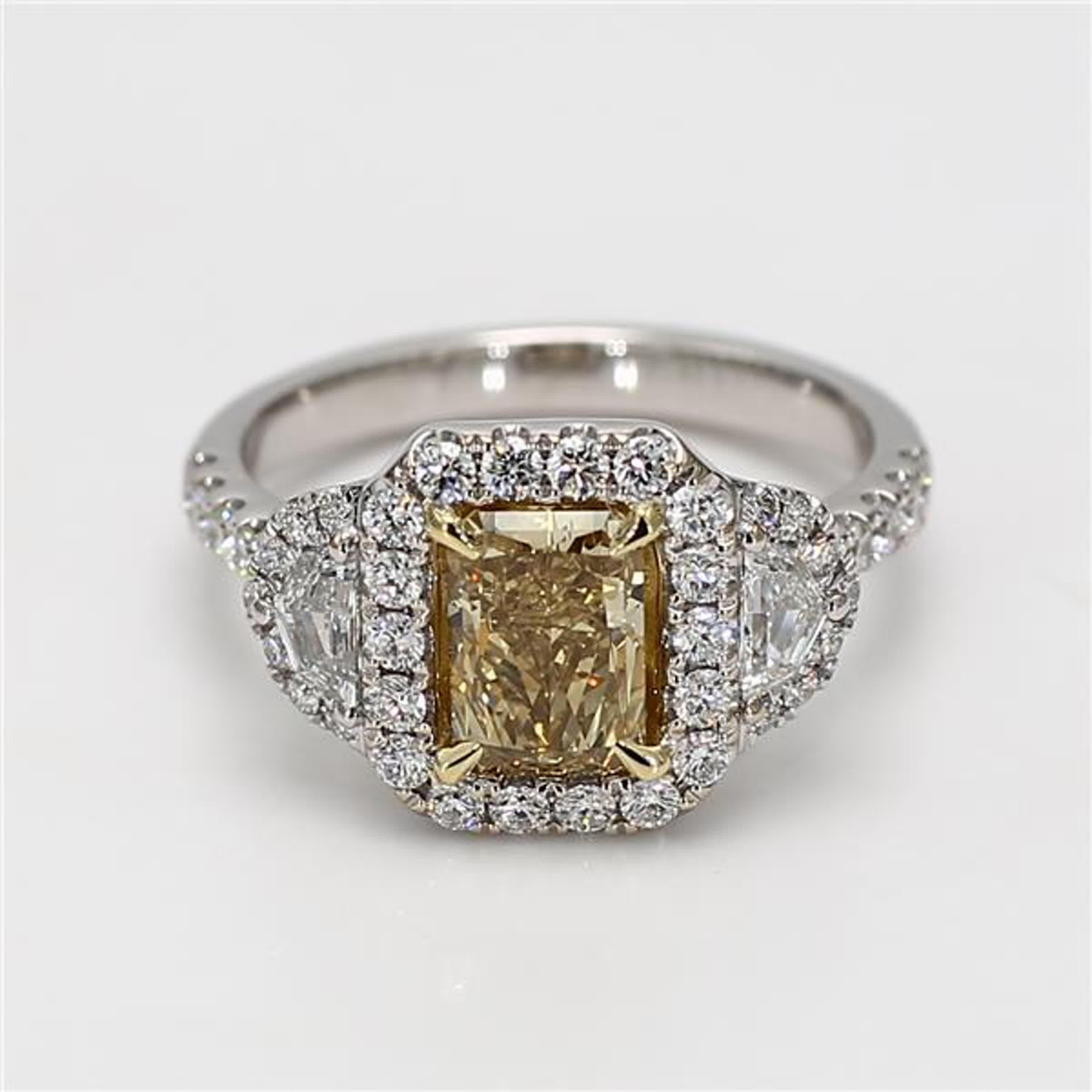 RareGemWorld's classic diamond ring. Mounted in a beautiful 18K Yellow and White Gold setting with a natural radiant cut brownish-yellow diamond. The yellow diamond is surrounded by natural trapezoid cut white diamond and round natural white diamond