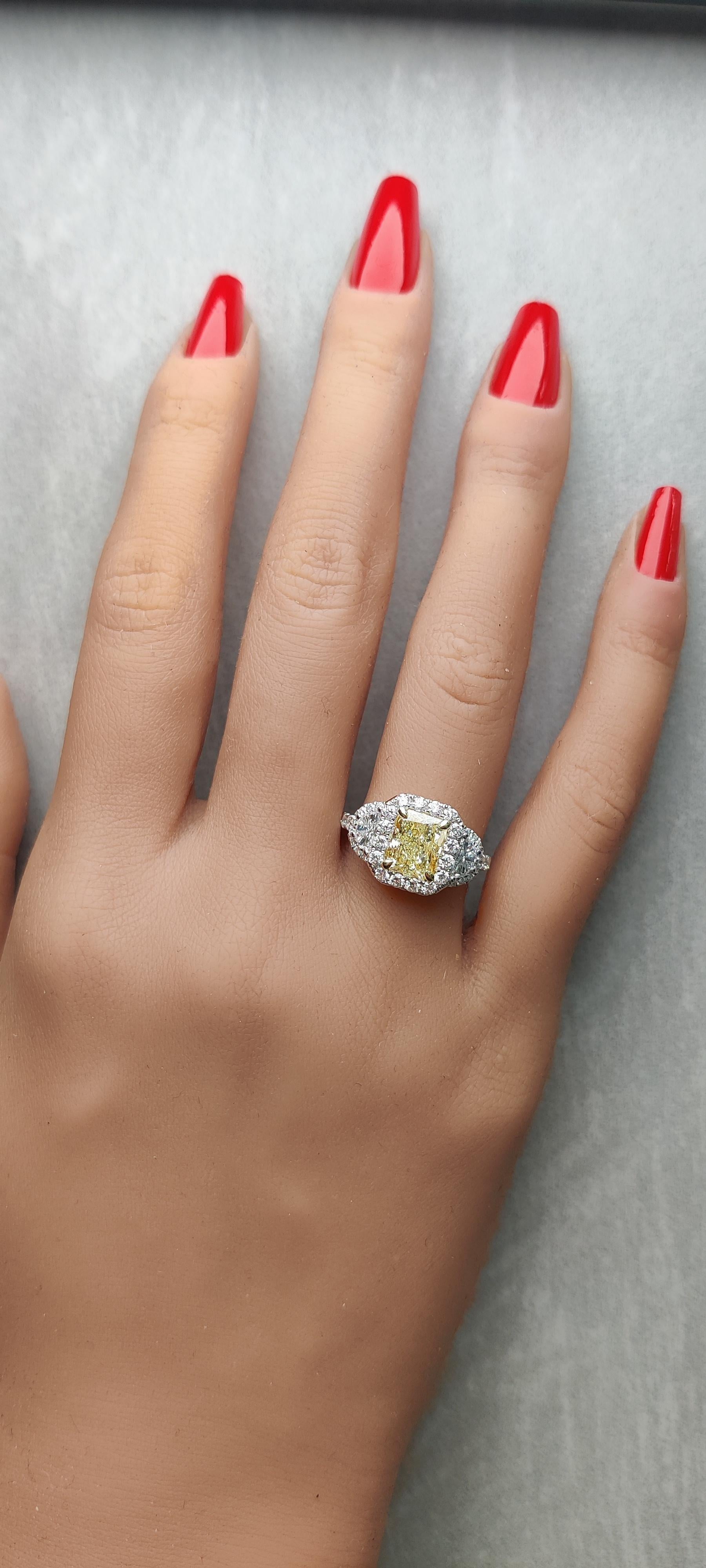 RareGemWorld's classic diamond ring. Mounted in a beautiful Platinum and 18K Gold setting with a natural radiant cut yellow diamond. The yellow diamond is surrounded by two GIA certified natural half moon cut white diamonds and round natural white
