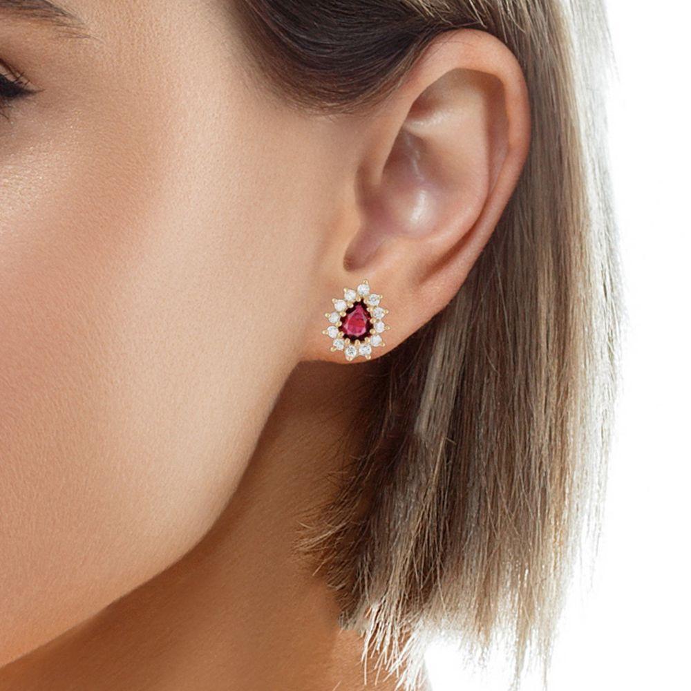 GIA certified No Heat Thai ruby and diamond yellow gold stud earrings! Each earring has an exceptioinally vibrant red, pear-shaped ruby weighing an estimated 1.50 carats. The earrings are set in 14 karat yellow gold with a three-pronged diamond halo
