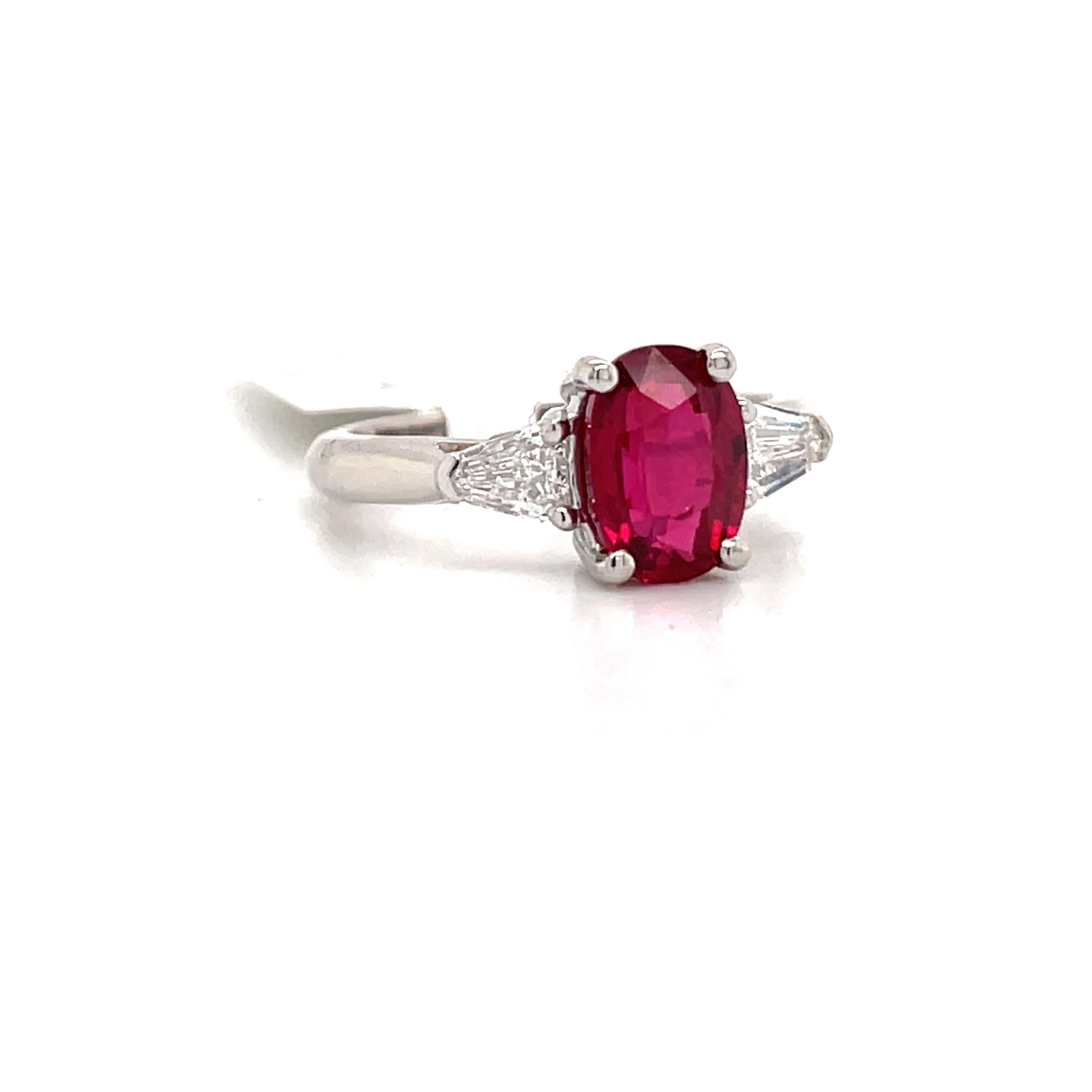 GIA Certified three stone ring featuring one oval shape red Ruby weighing 2.01 carats flanked with two bullets weighing 0.41 carats, crafted in Platinum. 
