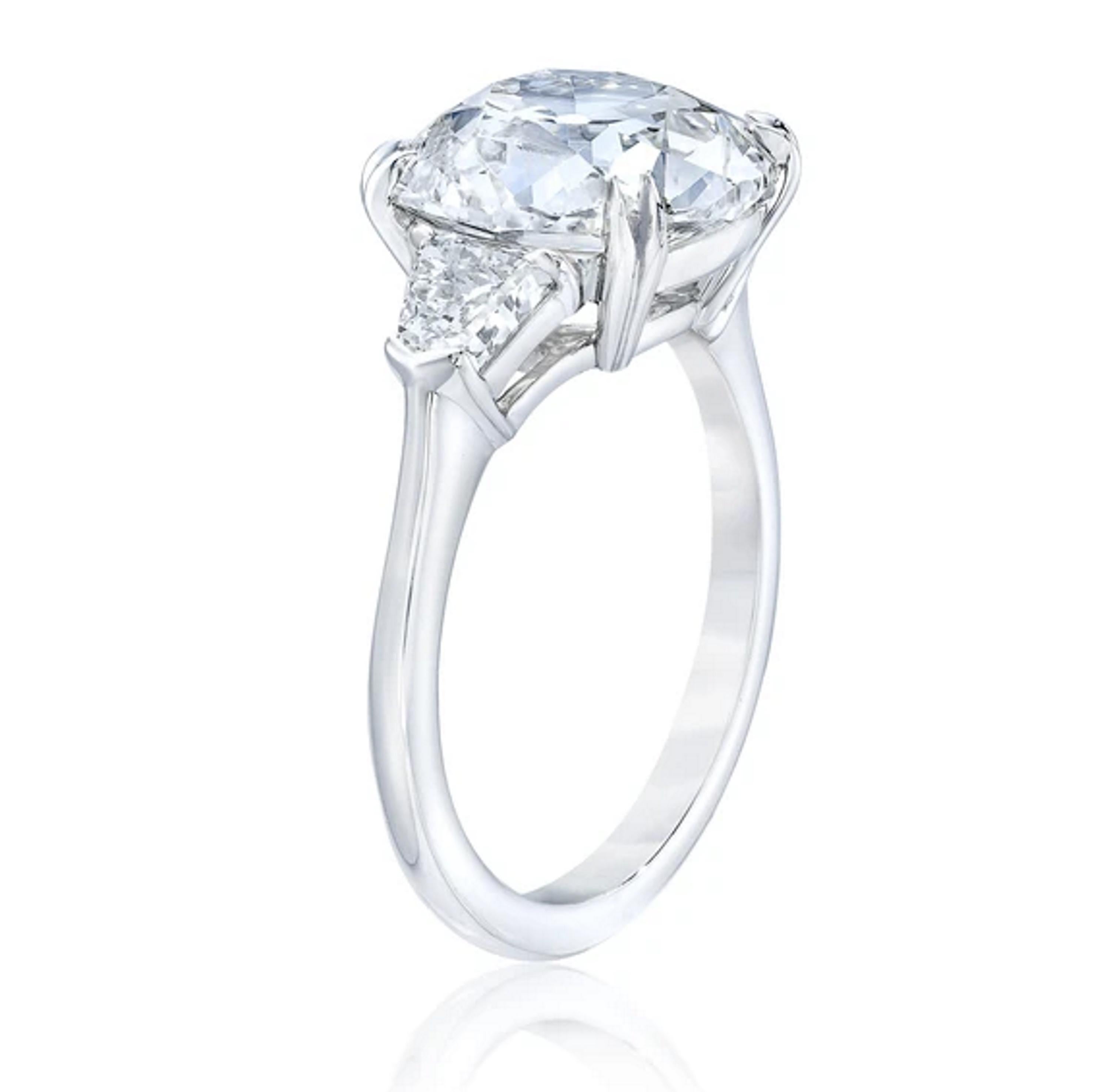 This exquisite ring features an old mine brilliant cut diamond, weighing 4 carats with a color grade of O-P and clarity of SI1. 

The diamond showcasing a unique squarish shape with soft, rounded corners, typical of the old mine cut, which