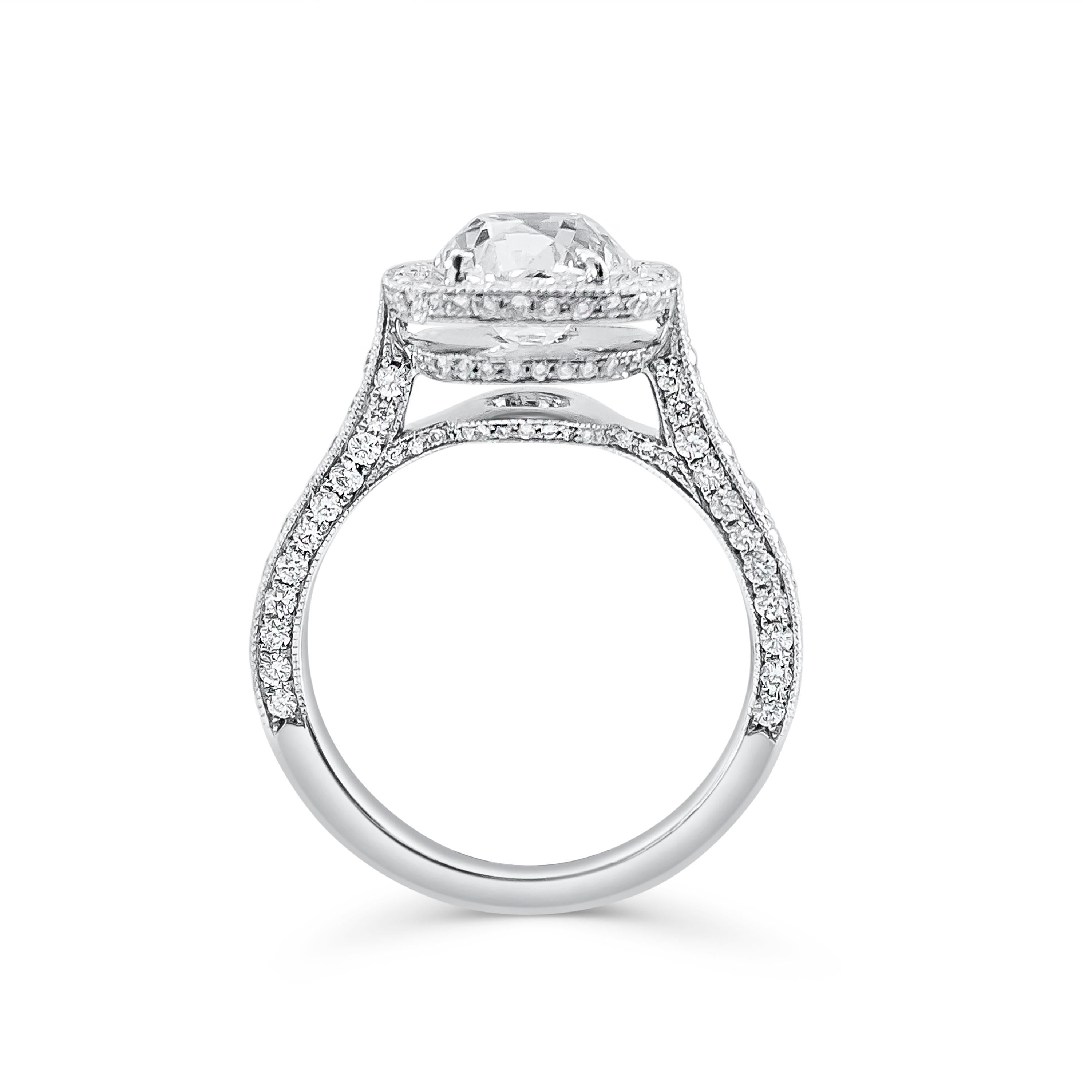 An incredible antique-looking ring, spotlighting a 2.10 carats old mine brilliant cut diamond, set on a four prong setting. Surrounded by a halo and accented by a diamond encrusted shank of sparkling round cut diamonds weighing 1.15 carats total.