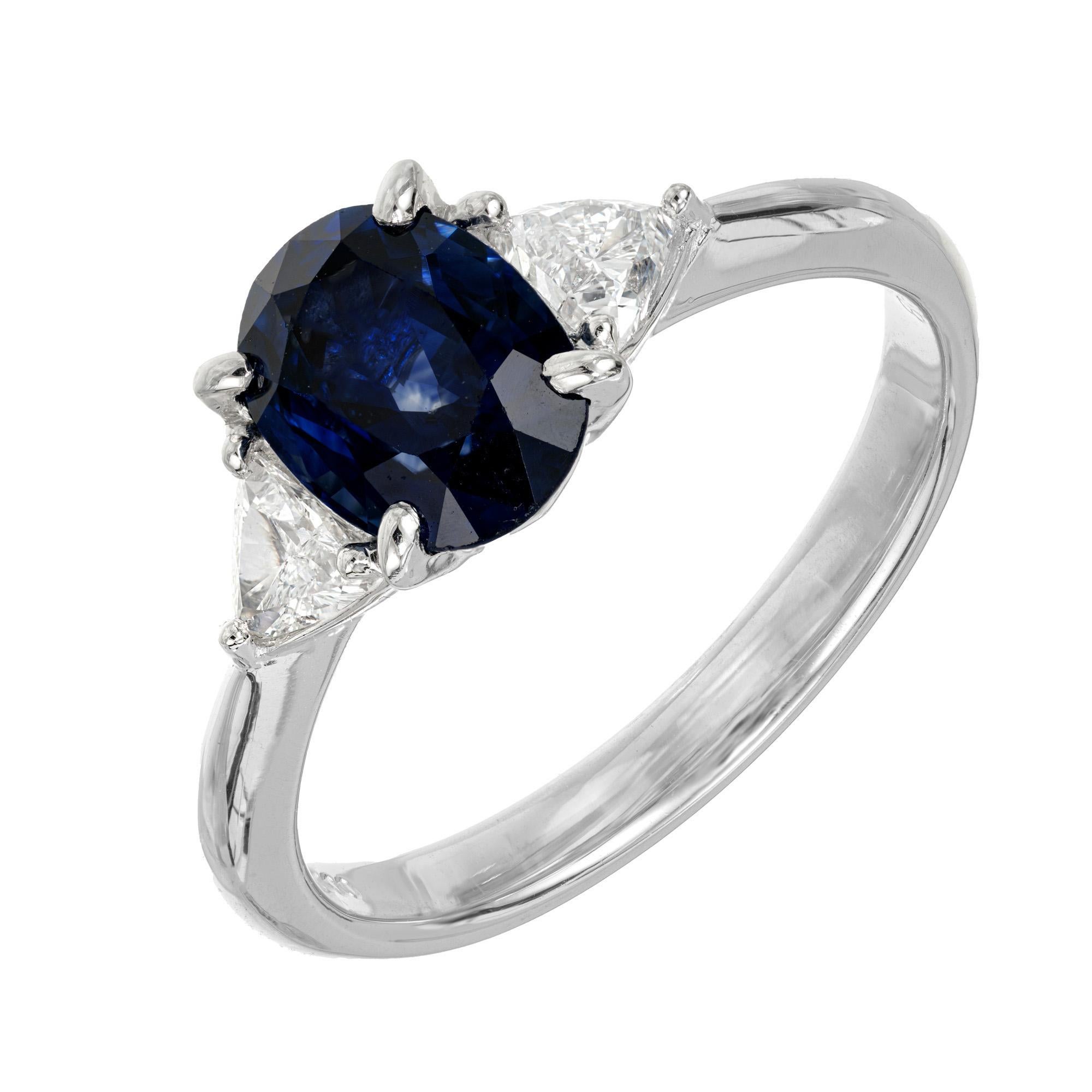 Deep blue sapphire and diamond engagement ring. GIA certified oval 1.85 carat blue sapphire center stone set in a platinum three-stone setting with 2 G-H (near colorless) trilliant cut side diamonds. The sapphire is simple heat only.  

1 oval blue