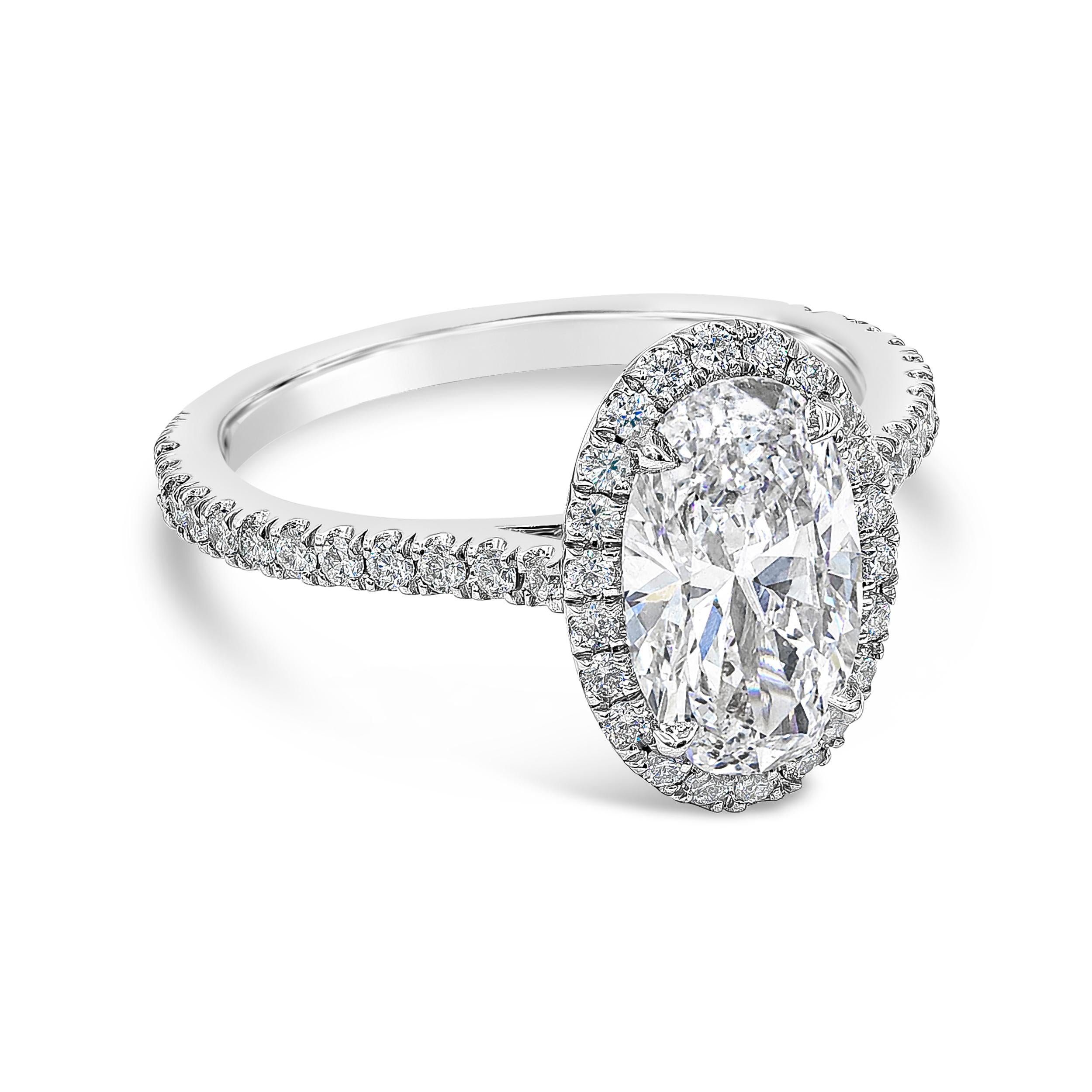 A classic halo style engagement ring showcasing a beautiful 1.71 carat elongated oval cut diamond certified by GIA as D color and SI2 clarity. Center diamond is surrounded by a brilliant diamond halo, set in an accented mounting made in polished