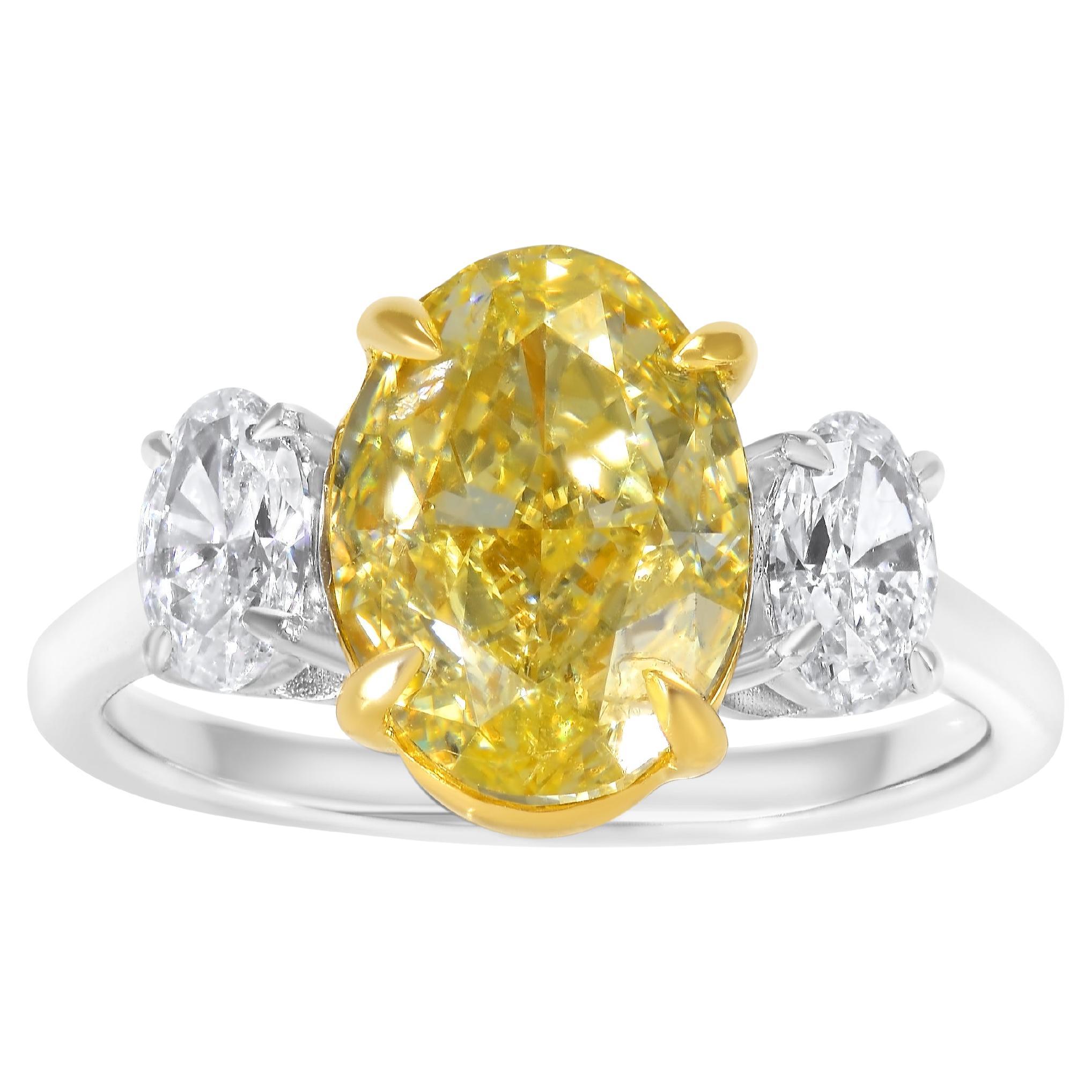 Anillo de tres piedras con diamante amarillo fantasía oval certificado por GIA