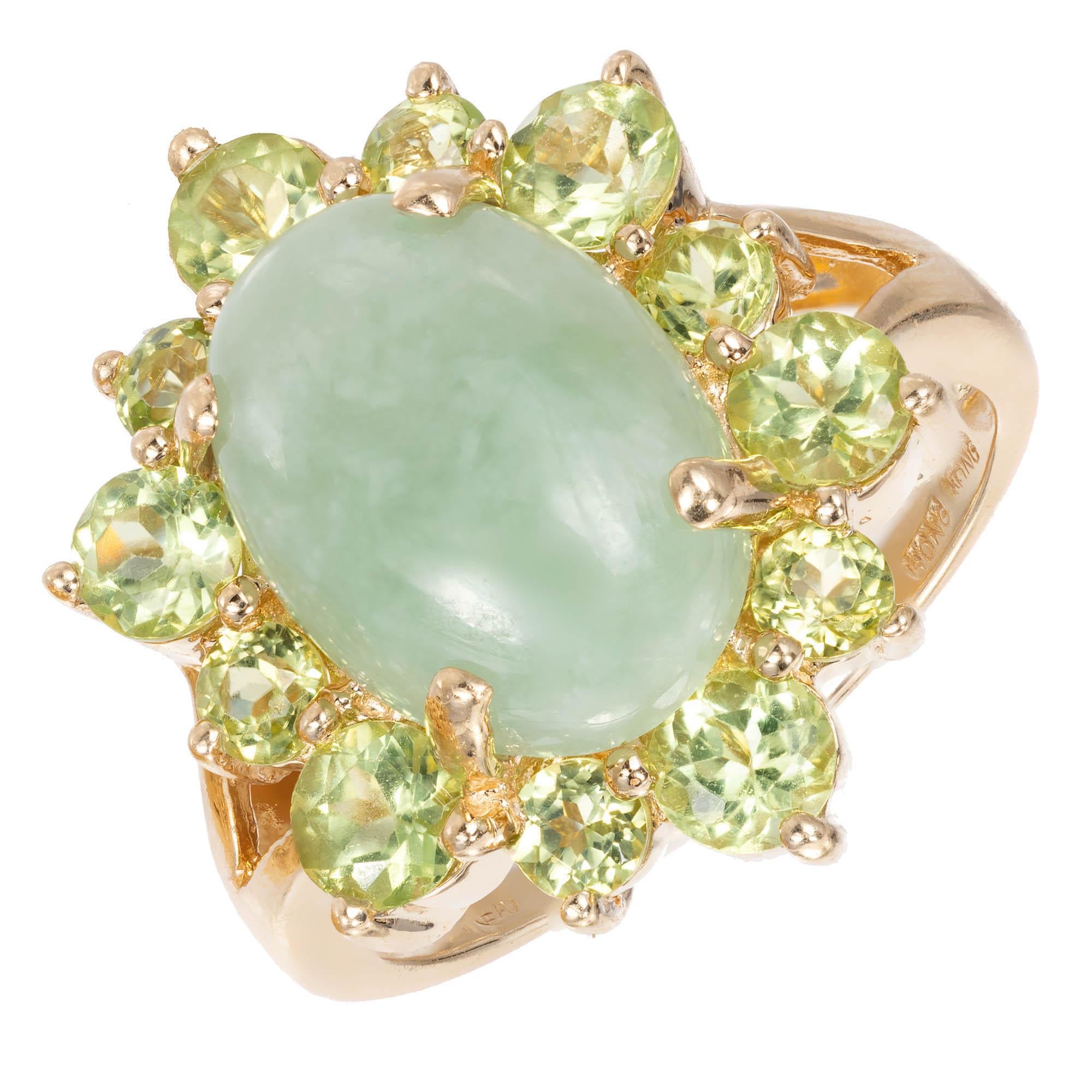  Jadeite Jade and Peridot cocktail ring. Large oval natural light green Jadeite Jade cabochon surrounded by round a green Peridot halo alternating in size to give dimension to this ring.

1 oval cabochon mottled light green Jadeite Jade, 14.04 x