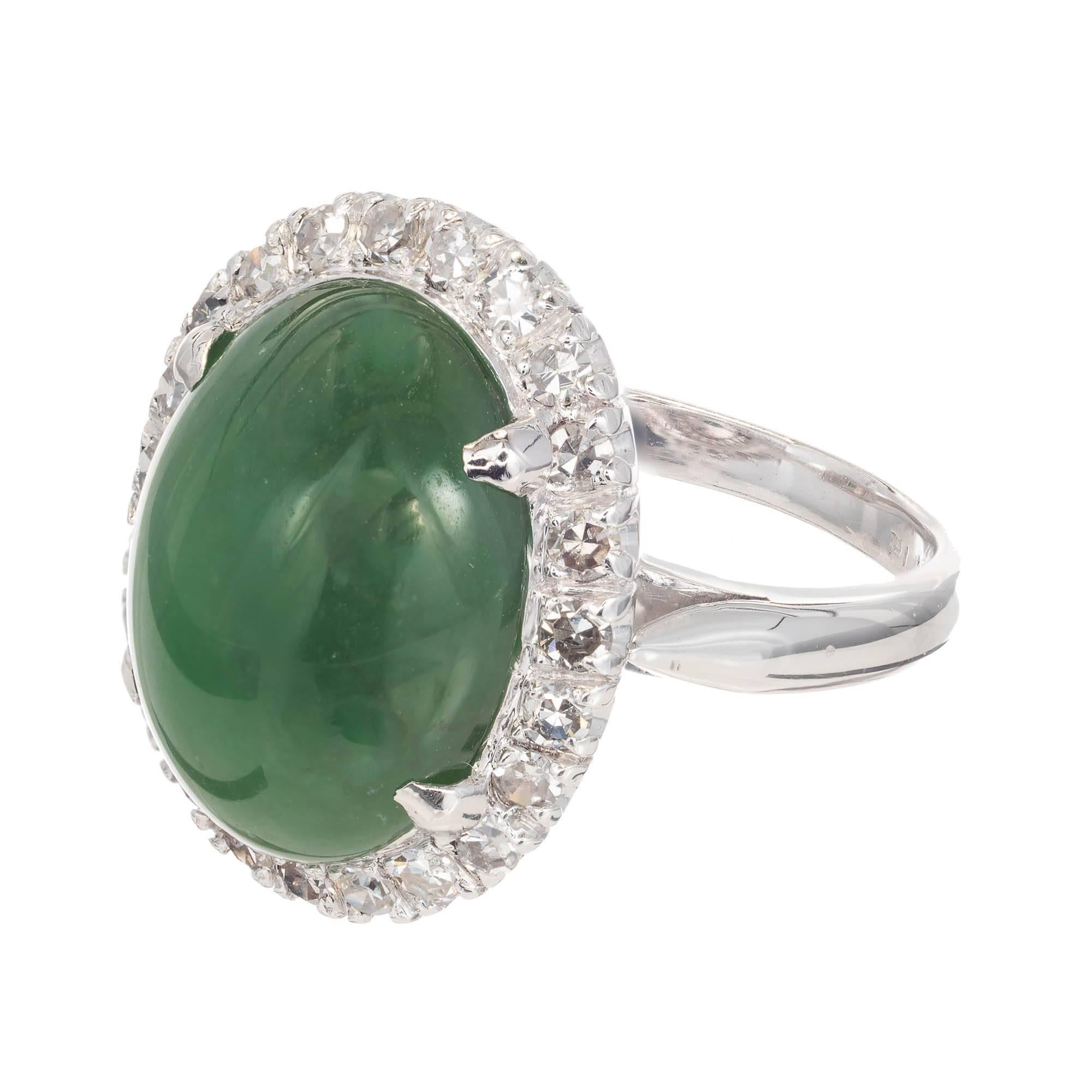 Green jade and diamond cocktail ring. Natural green oval jade cabochon surrounded by a halo of round diamonds in a platinum setting. GIA certified.

1 oval cabochon green jadeite jade 13.77 x 10.37x 5.74 GIA Certificate # 1196149219
24 single cut