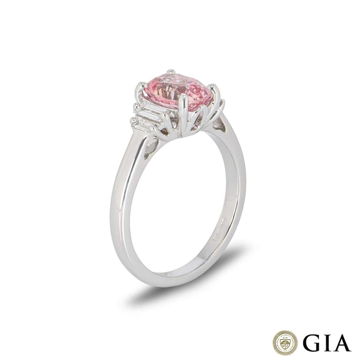 A beautiful 18k white gold pink sapphire and diamond ring. The Padparasha pink cushion cut sapphire weighs 1.86ct and displays an orange-pink colour. Set to either side of the sapphire are 4 baguette cut diamonds with a total weight of 0.23ct. The
