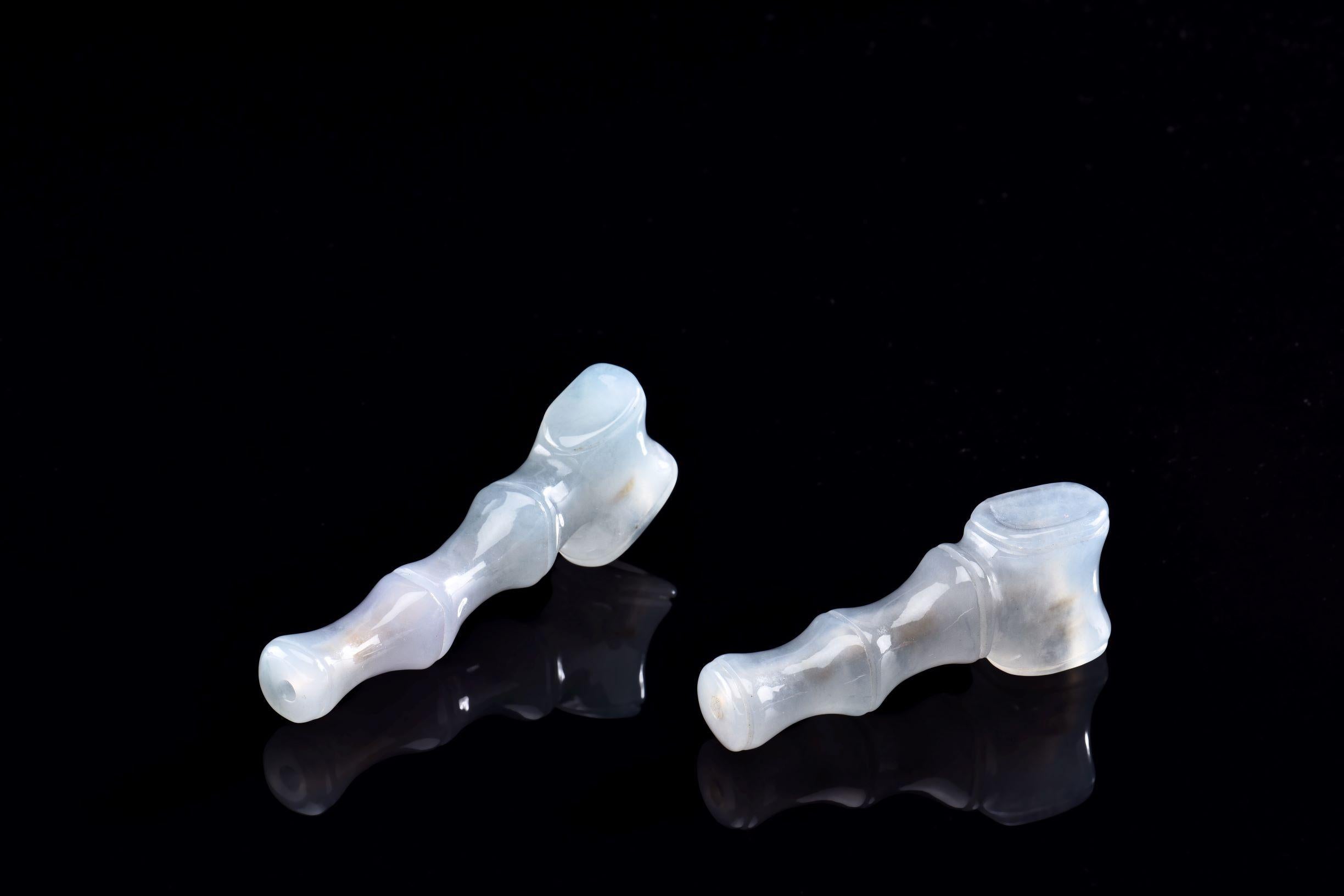 Coppia di pipe da fumo in giada naturale traslucida grigio-verde, una più piccola e una più grande. La pipa più piccola misura circa 62,10 x 23,61 x 14,47 mm e pesa circa 32 grammi, mentre quella più grande misura circa 79,82 x 21,26 x 11,84 mm e