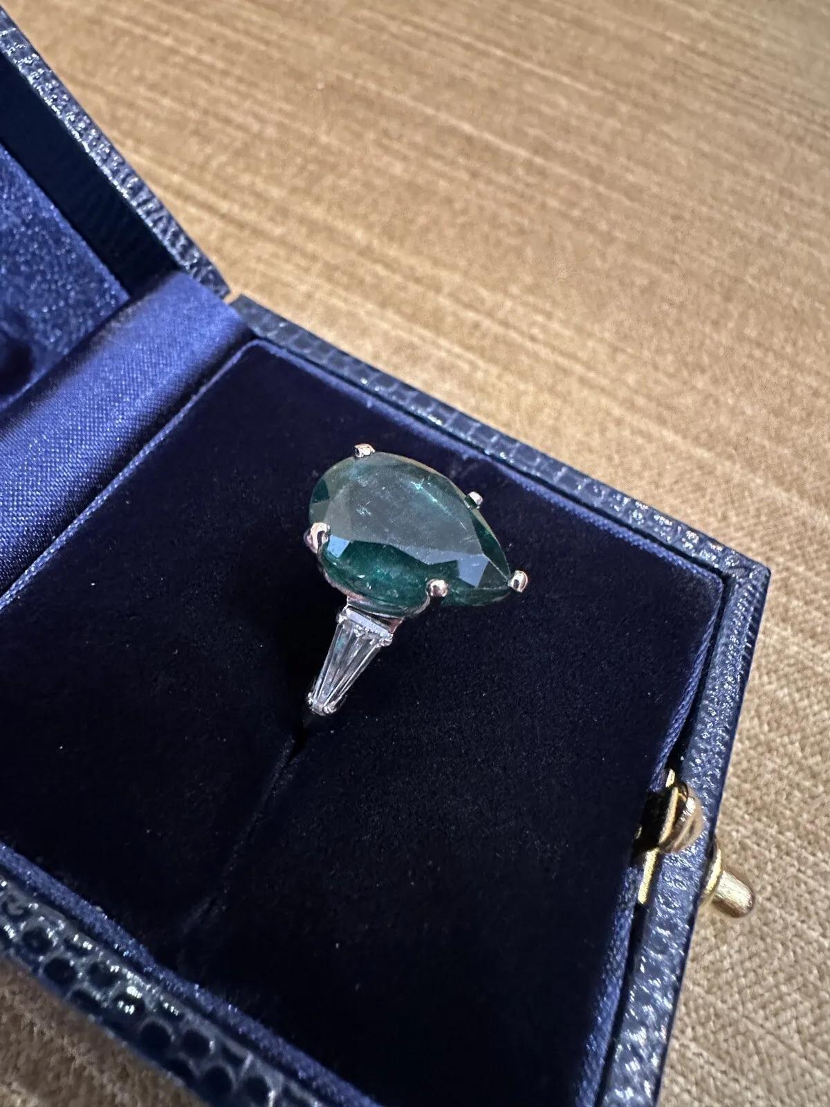 GIA Certified Pear Emerald 5.96 Carat and Diamond Ring in Platinum 

Vintage Emerald and Diamond Ring features a 5.96 carat Natural Pear Shaped Emerald accented by 2 Tapered Baguette Diamonds set in Platinum.

Emerald weight is 5.96 carats and is