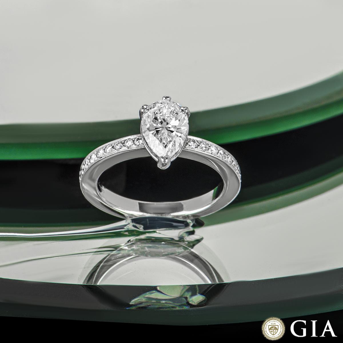 An beautiful platinum diamond engagement ring. The central pear shape diamond weighs 1.21ct, is G colour and VS1 clarity. The centre diamond is complemented with 11 round brilliant cut diamond set on each of the shoulders totalling 0.29ct, well