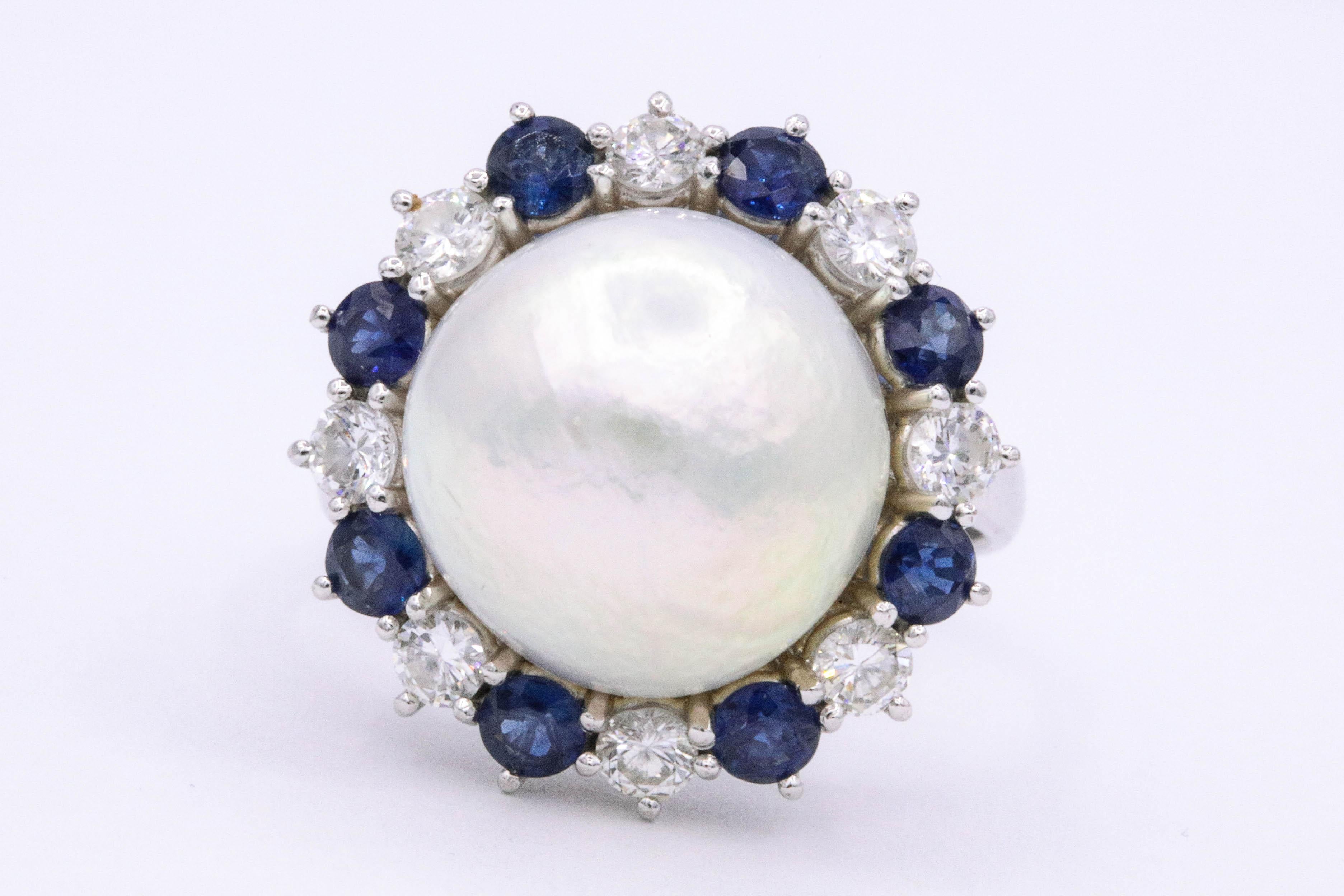 Platinum ring featuring one GIA pearl measuring 13 MM flanked with diamond and sapphires weighing 1 carat. 