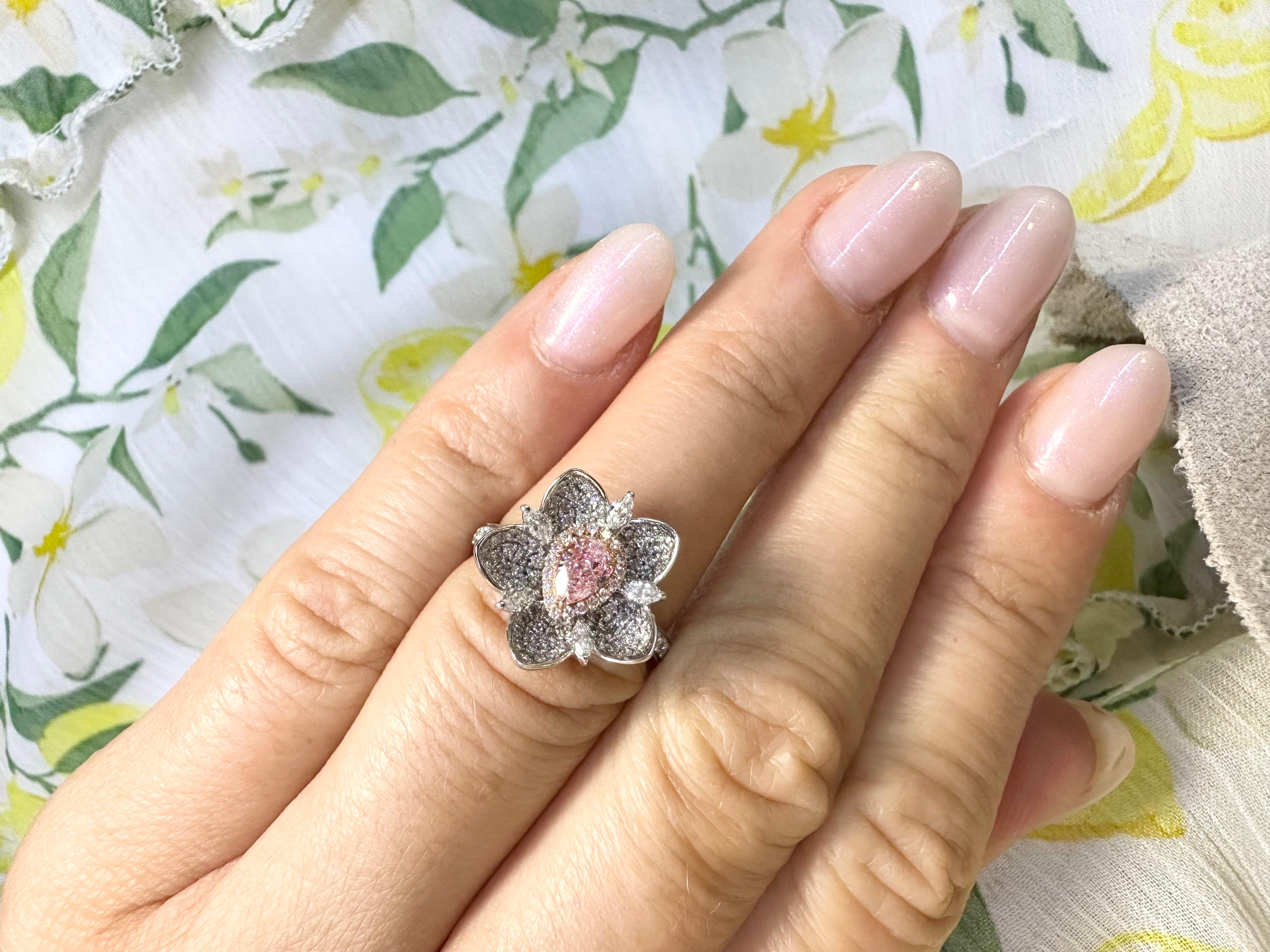 Stunning Floral cocktail ring made with GIA certified pink diamond in center and small diamonds all around, this lotus has unbelievable sparkle!

Metal Type: 18KT
Gram Weight:5.77 grams 

Natural Pink diamond(s):
Color: Faint Pink
Cut:Pear