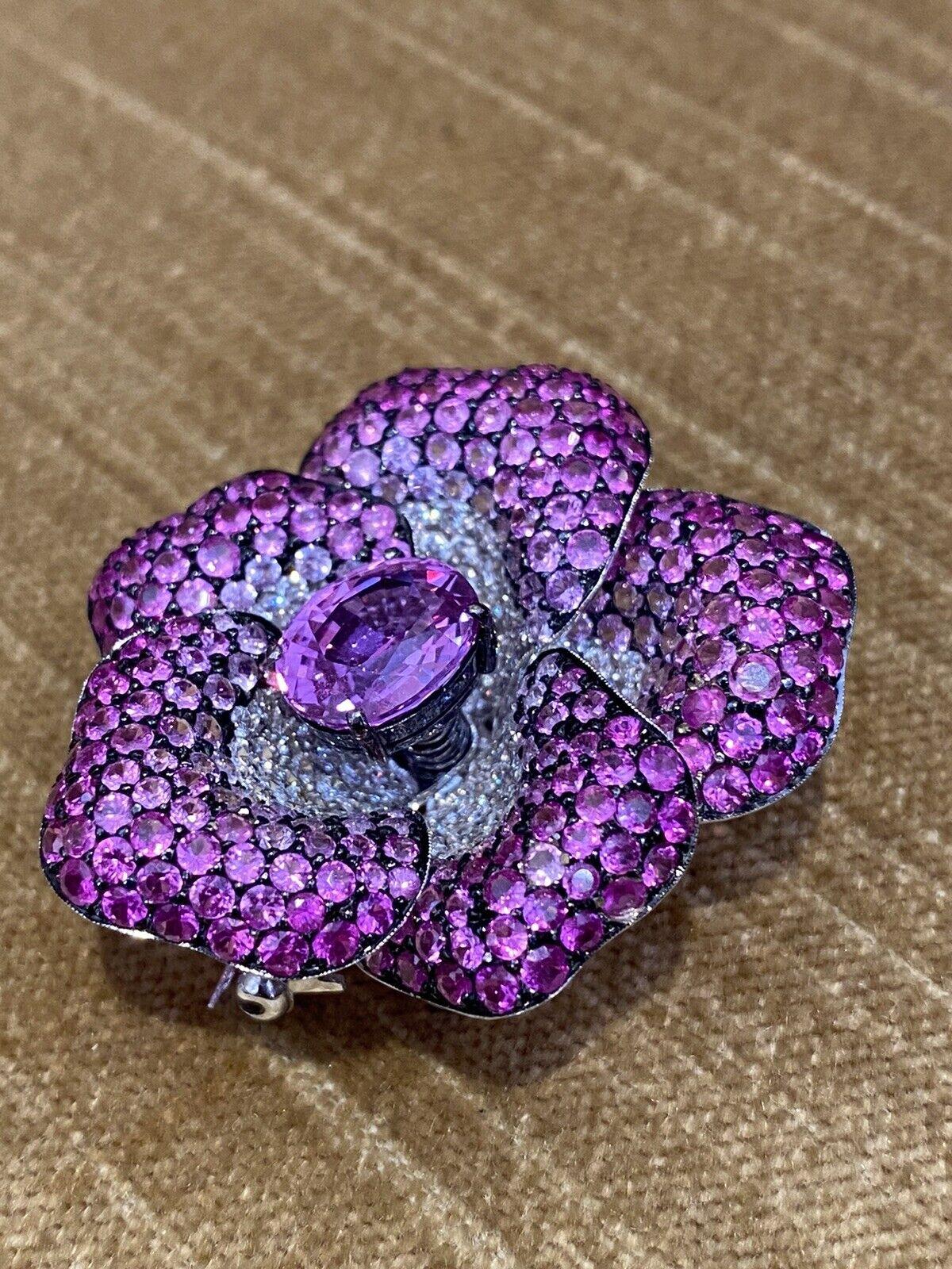 GIA Certified Pink Sapphire and Diamond Flower Pin/Brooch in 18k White Gold

Diamond and Sapphire Flower Pin features a 4.37 carat Natural Oval Purplish Pink Sapphire in the center, surrounded by Pave set Round Diamonds and Pink Sapphires graduating