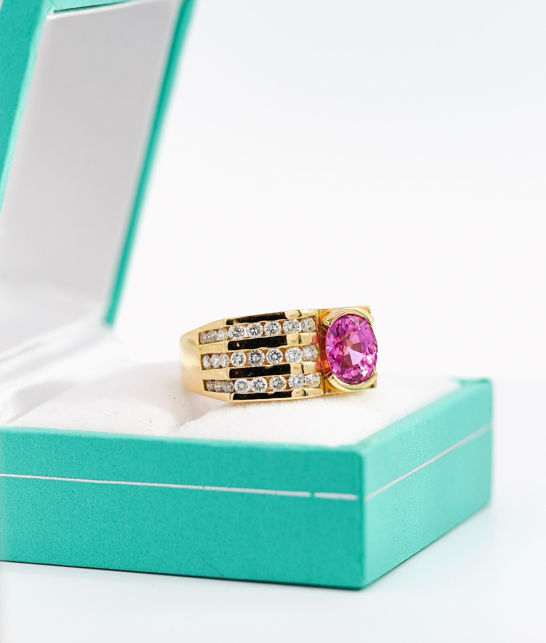 18K yellow gold ring, weighing 10.29 grams and boasting a size 8. Featuring a 2.77 Carat oval cut natural Pink Sapphire with a half bezel setting. Complemented with 24 round-cut diamonds in channel setting. The ring features a stunning horizontal