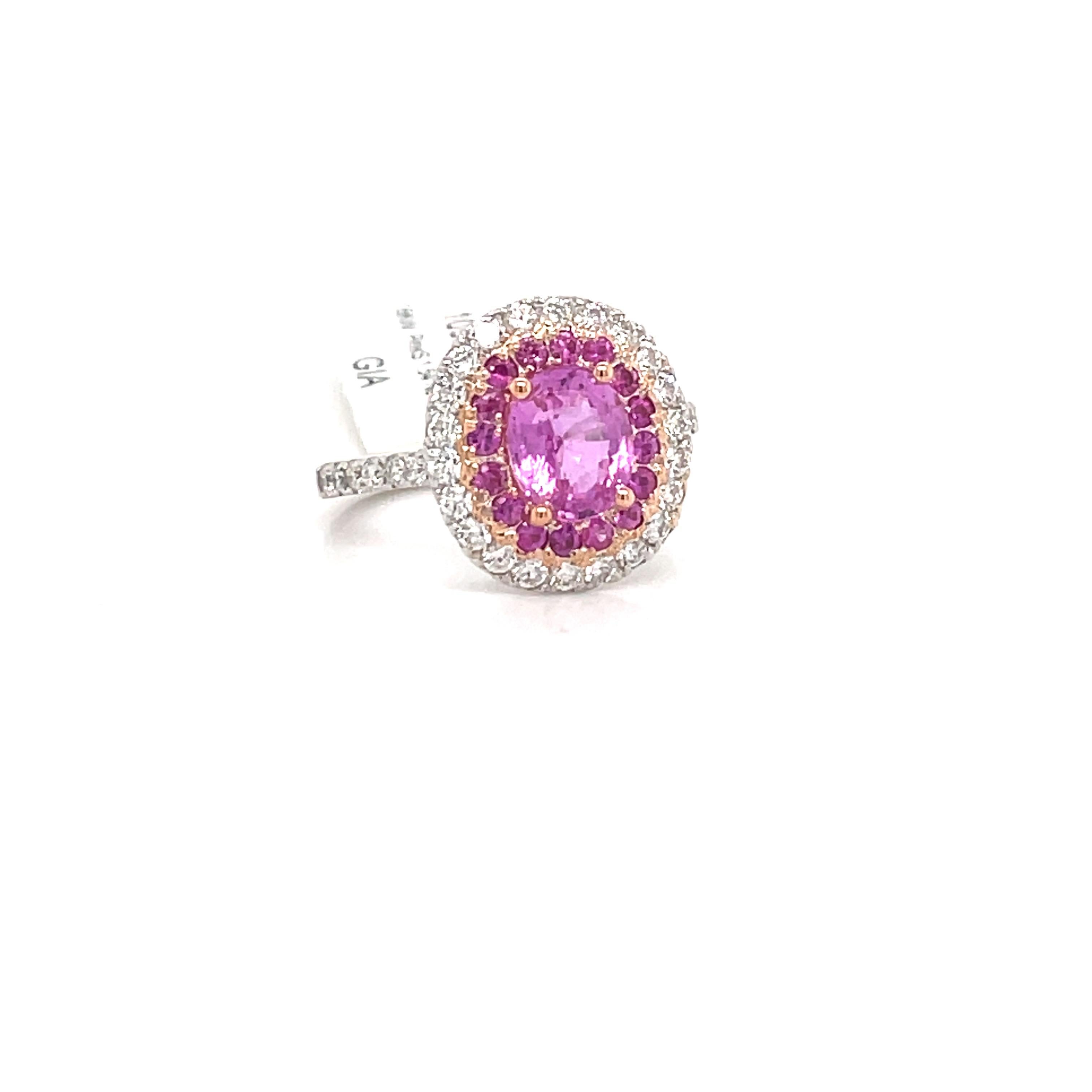GIA Certified ring featuring one pink oval Sapphire weighing 1.54 carats flanked with a pink sapphire and diamond halo weighing 0.73 carats, crafted in 18k white gold. 