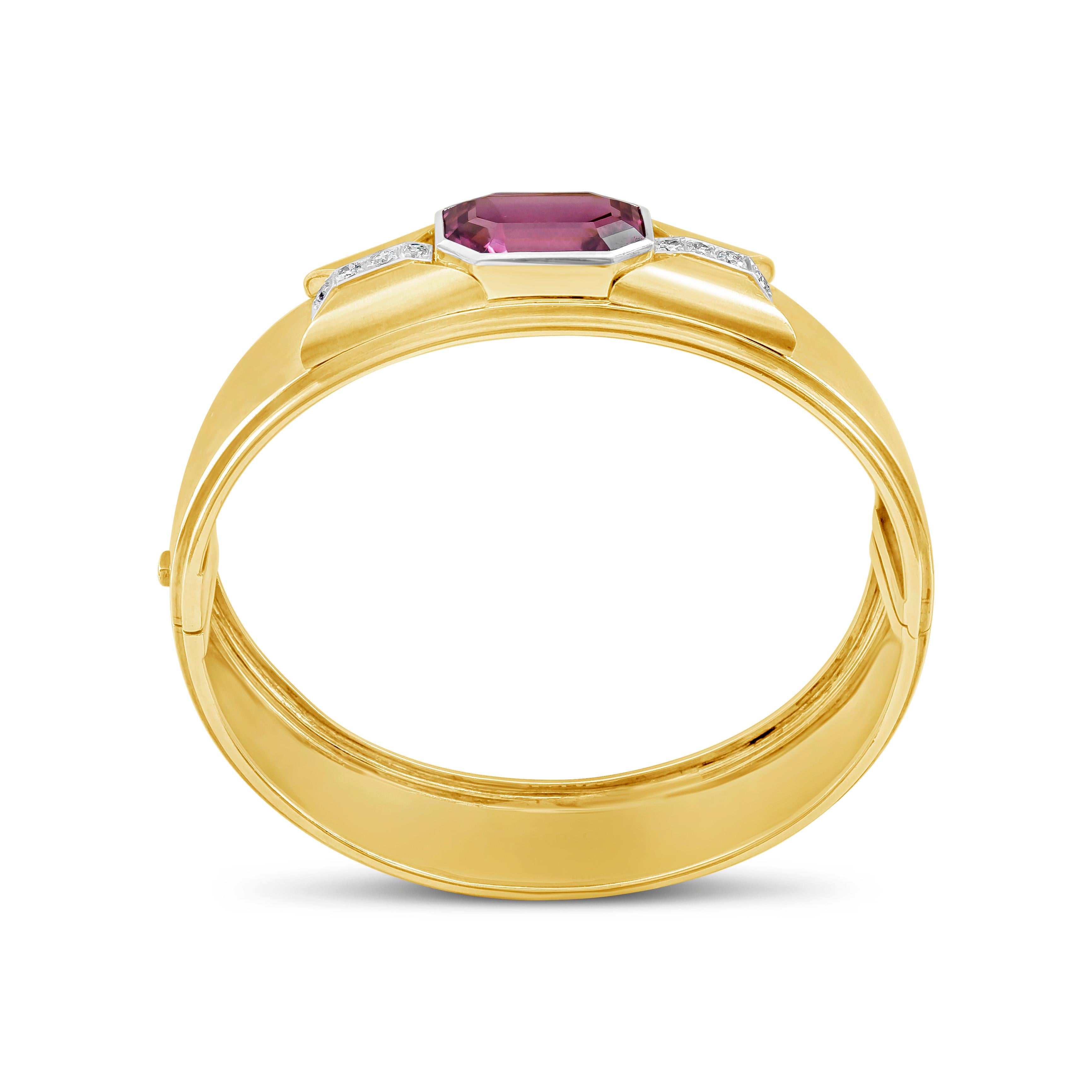 An antique bangle bracelet showcasing a octagonal step-cut GIA Certified pink tourmaline 10.50 carats total, accented by 4 brilliant round diamonds on each side weighing 0.30 carats. Set and made in 18K Yellow Gold, Hinge clasp for secure fit. 