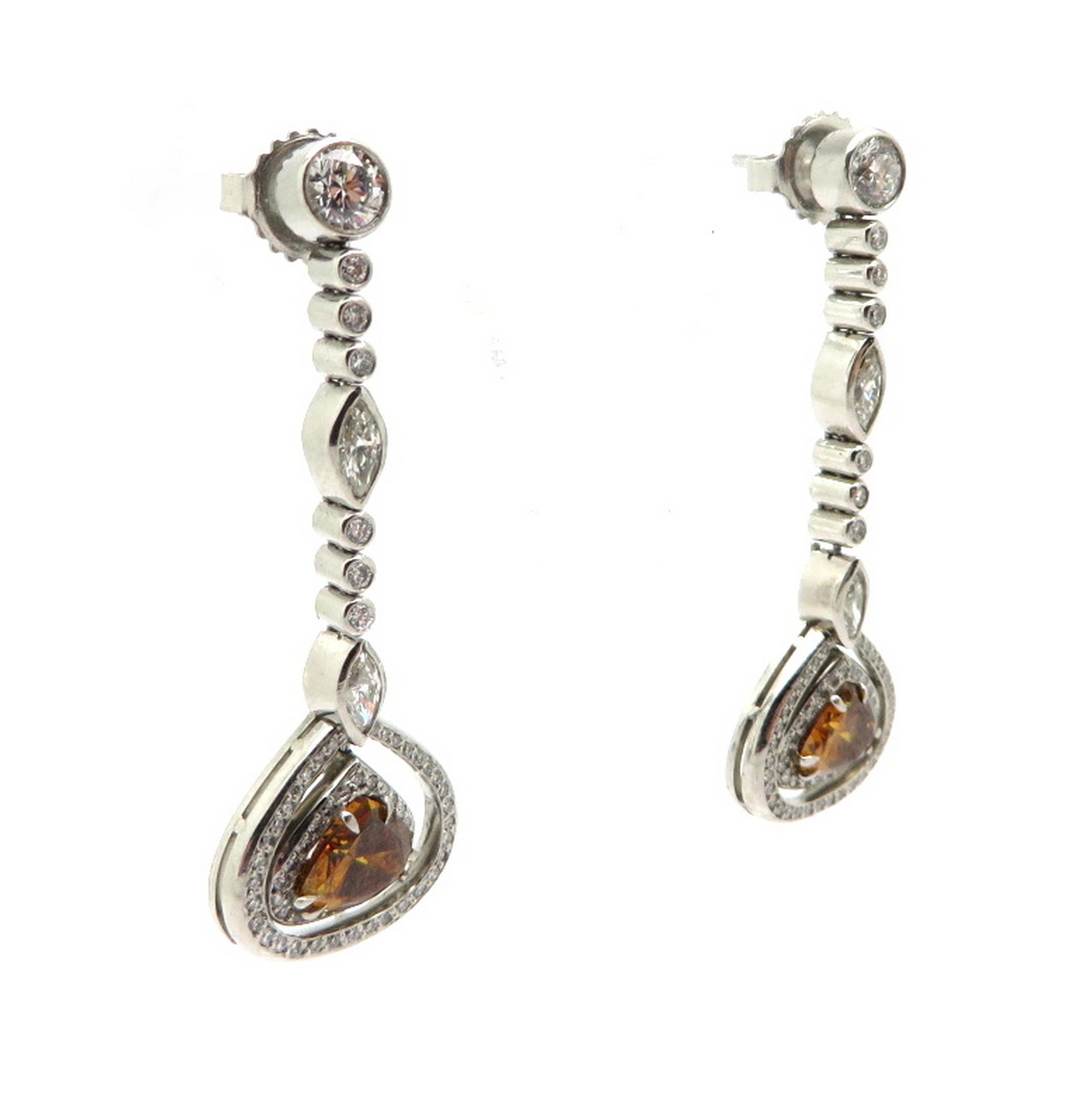 GIA certified platinum and 18K yellow gold brown and white diamond dangle earrings. Showcasing two pear shape fancy brown/ orange diamonds weighing 1.92 carats, set in 18K Yellow  Gold. GIA certificate # 11567294595. Featuring four bezel set