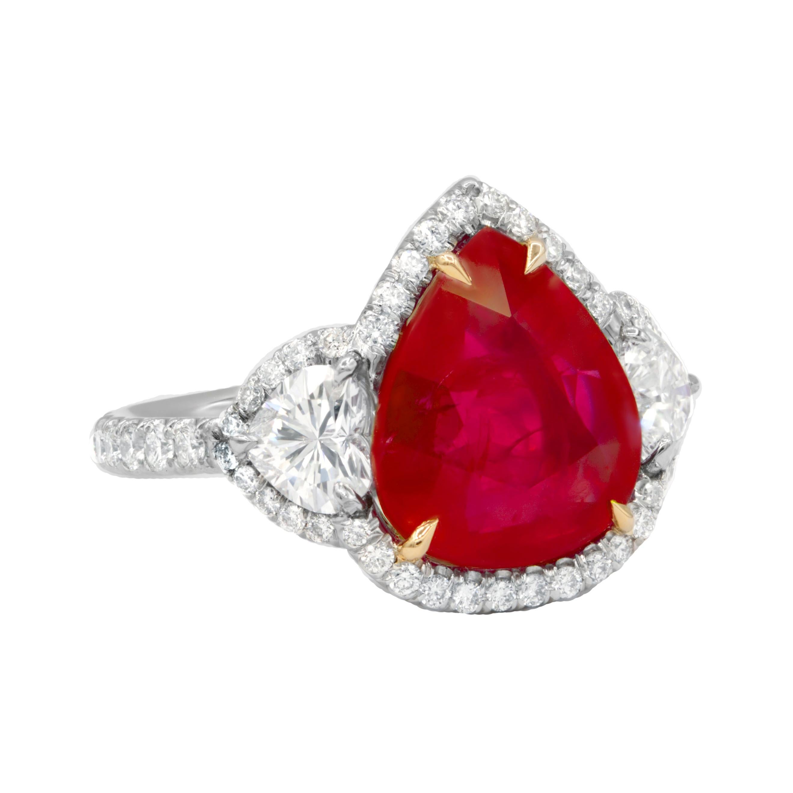 Magnificent combination of Ruby with heart shaped diamonds makes this ring spectacular! 
The center stone is 6.27 Carat Pear Shape ruby certified by GIA and set with two hearts on each side surrounded by round brilliant cut diamonds totaling 1.70