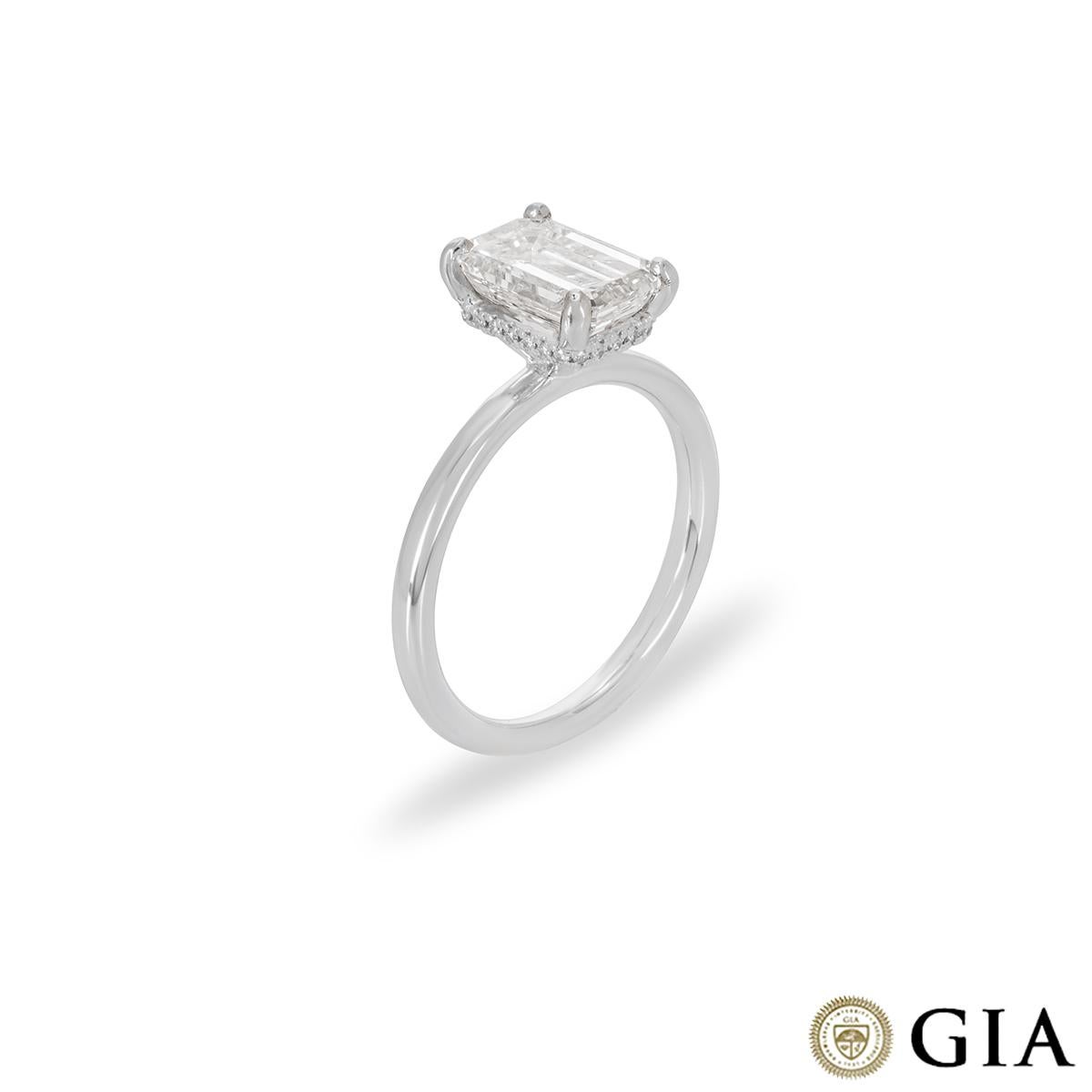 A mesmerising platinum diamond engagement ring. The solitaire is set to the centre with an emerald cut diamond weighing 1.80ct, H colour and VS1 clarity. The centre stone is accentuated by a hidden halo comprising of 24 round brilliant cut diamonds