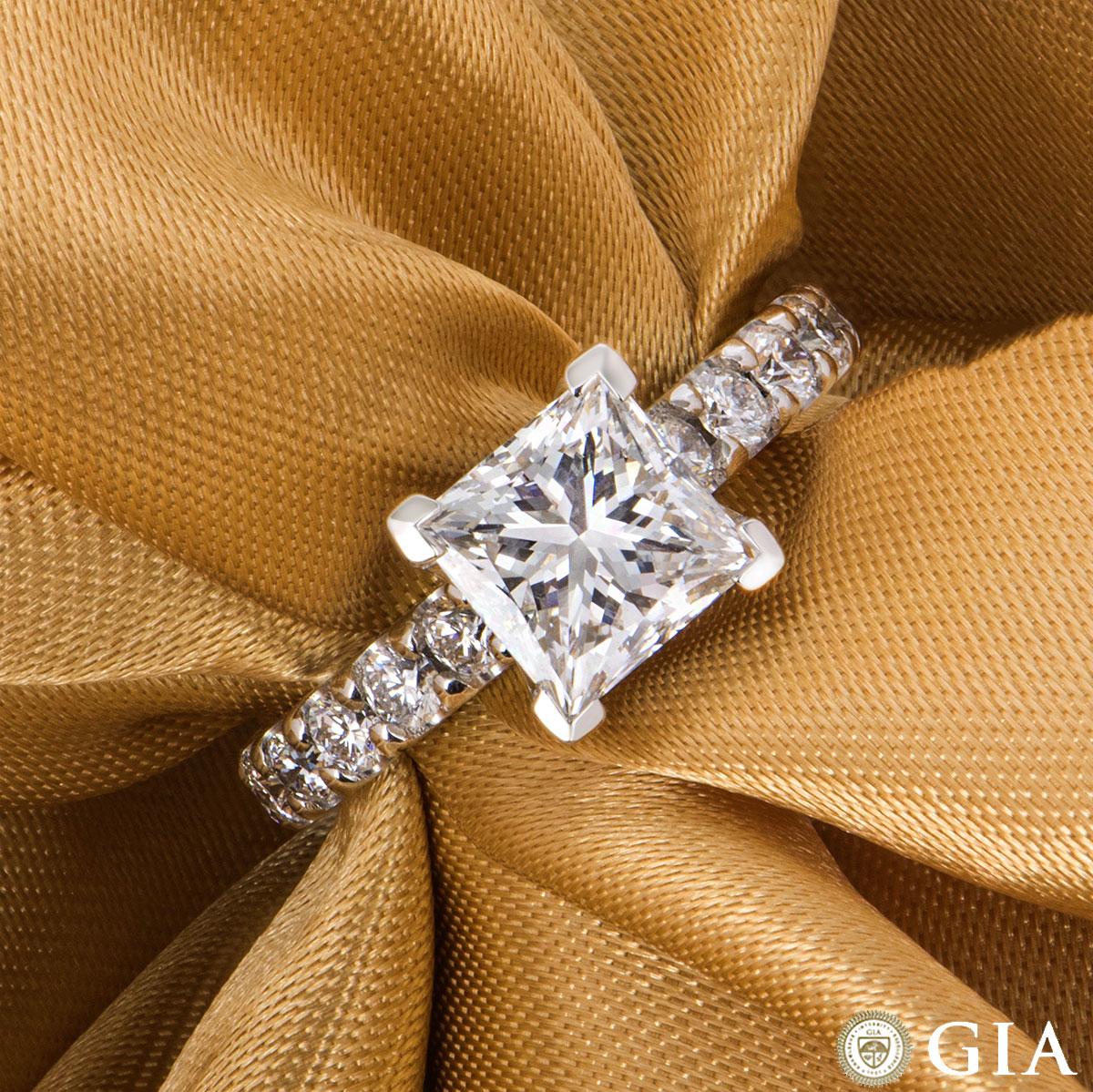 A stunning 18k white gold princess cut diamond ring. The ring features a 2.01ct, F colour and VVS1 clarity princess cut diamond in the centre with a four prong setting and 6 round brilliant cut diamonds on each shoulder with an approximate total