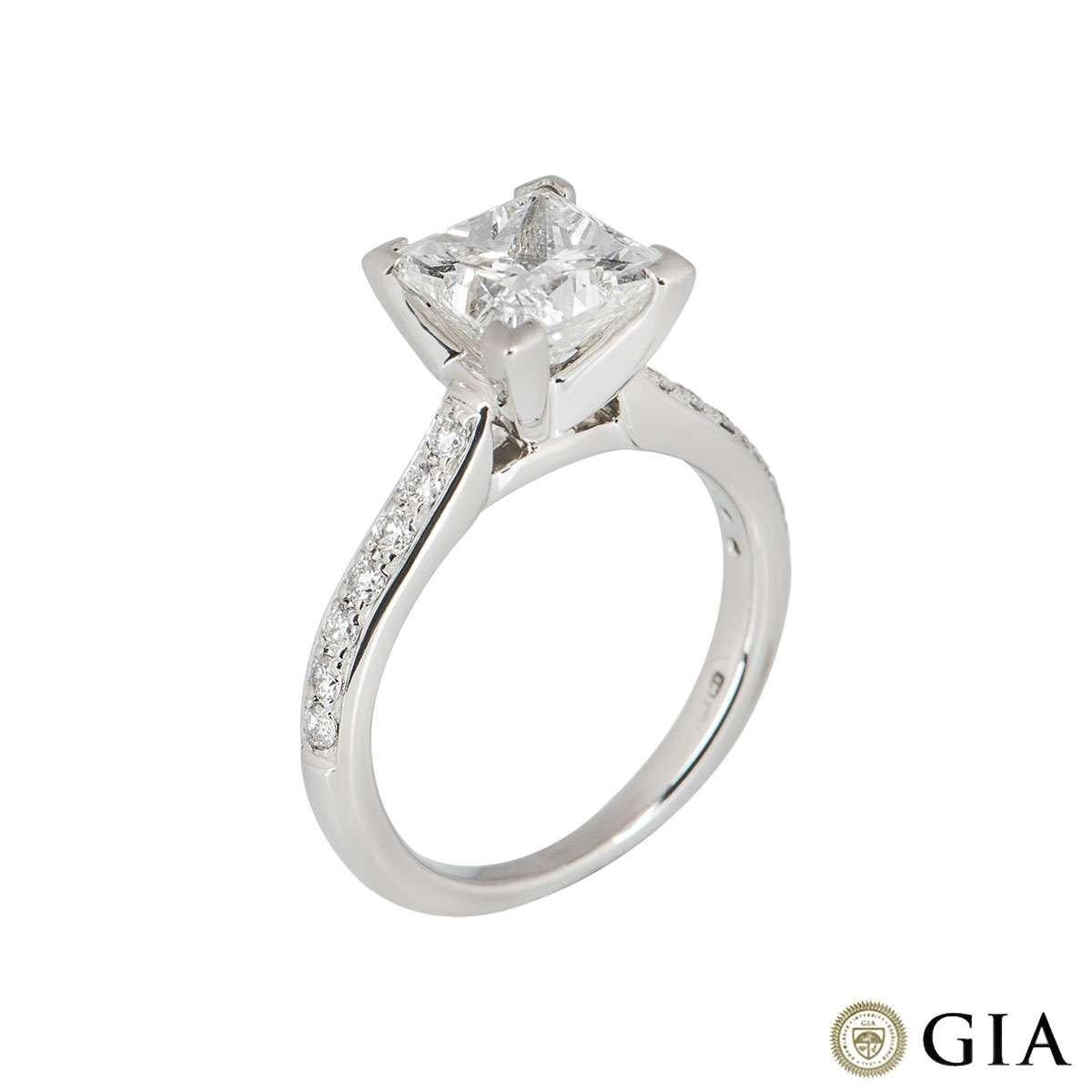 An elegant diamond ring in platinum. The ring is set to the centre with a claw set 2.02ct princess cut diamond, H colour and VS2 clarity, complete with GIA laser inscription. Accentuating the central diamond are pave set round brilliant cut diamond