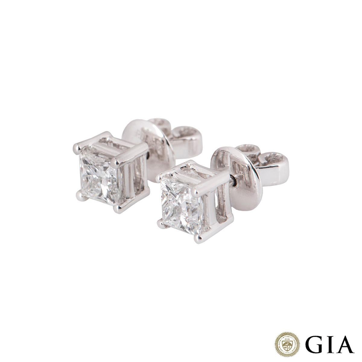 A pair of sparkly 18k white gold princess cut diamond earrings. Each earring features a princess cut diamond in a four claw setting. The first diamond weighs 0.70ct and the second has a weight of is 0.72ct, both F colour and VS1 in clarity. The