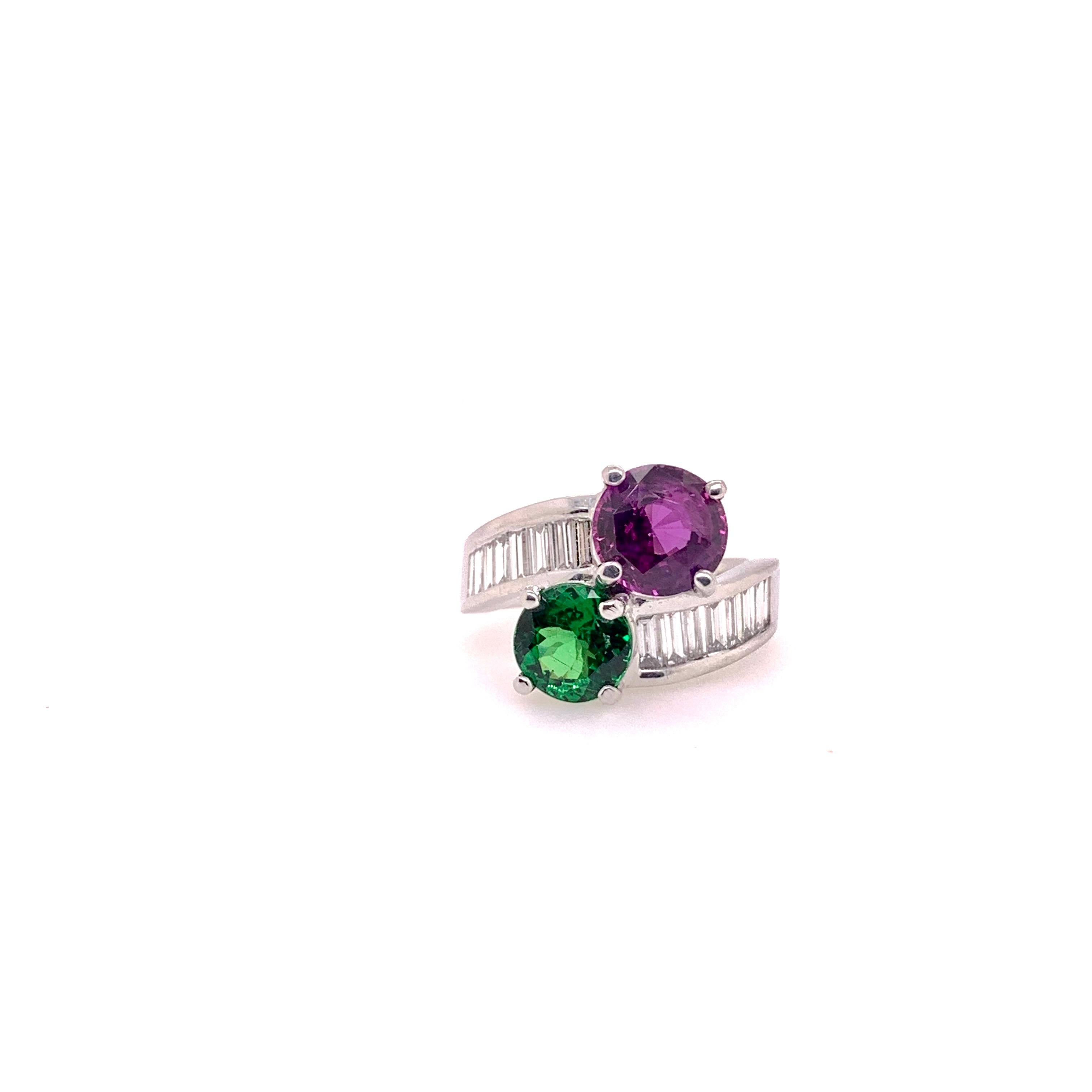 Amazing colorstone bypass ring!   A gorgeous, kelly-green tsavorite garnet opposed by a GIA certified purple-pink sapphire in a handmade 18k white gold diamond setting.  The round cut tsavorite weights 1.62 cts and the round cut sapphire is a