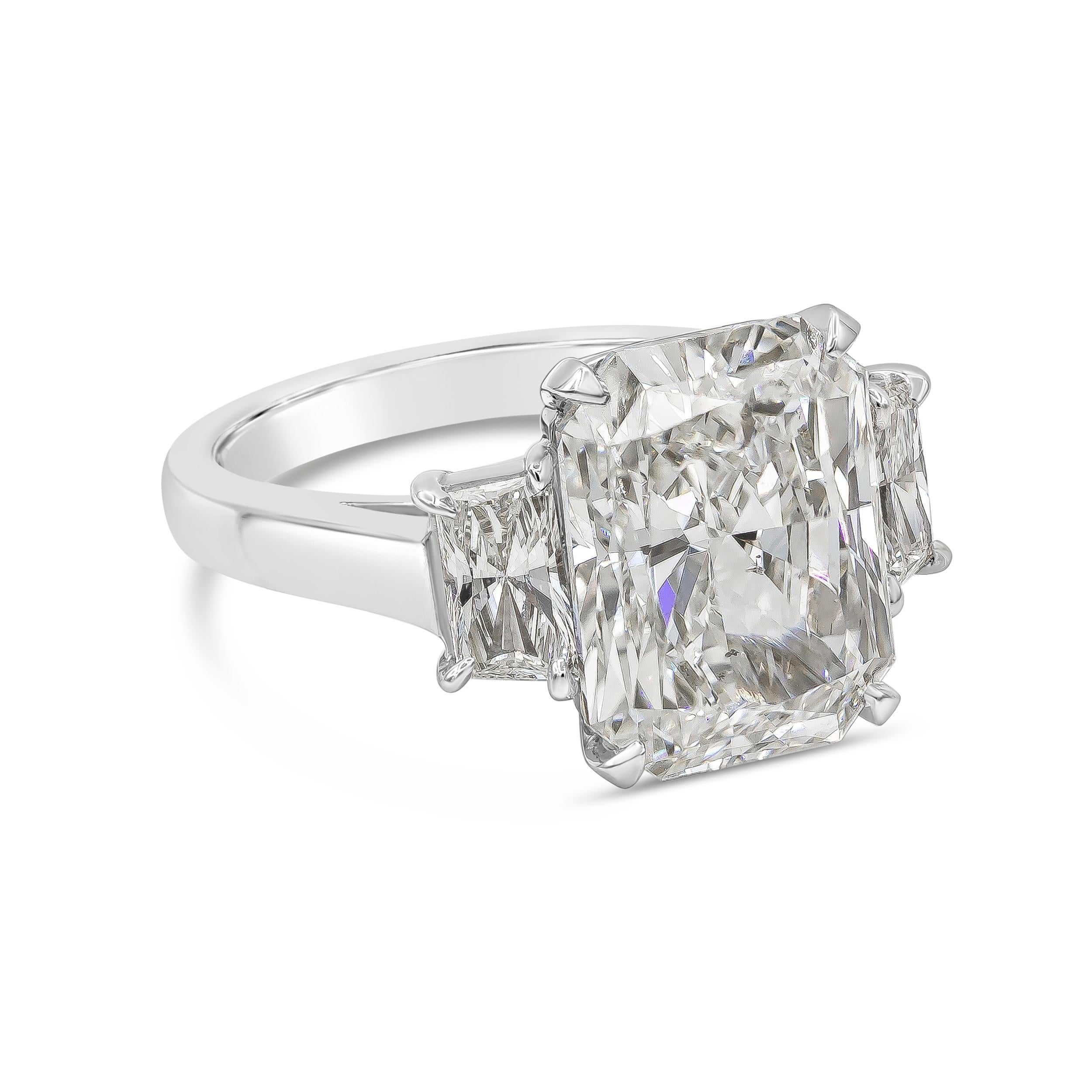 This classy and vibrant three-stone engagement ring showcasing 8.01 carat radiant cut diamond certified by GIA as J color, SI1 clarity, flanked by two trapezoid diamonds weighing 1.05 carats total. Set in a polished Platinum mounting.


