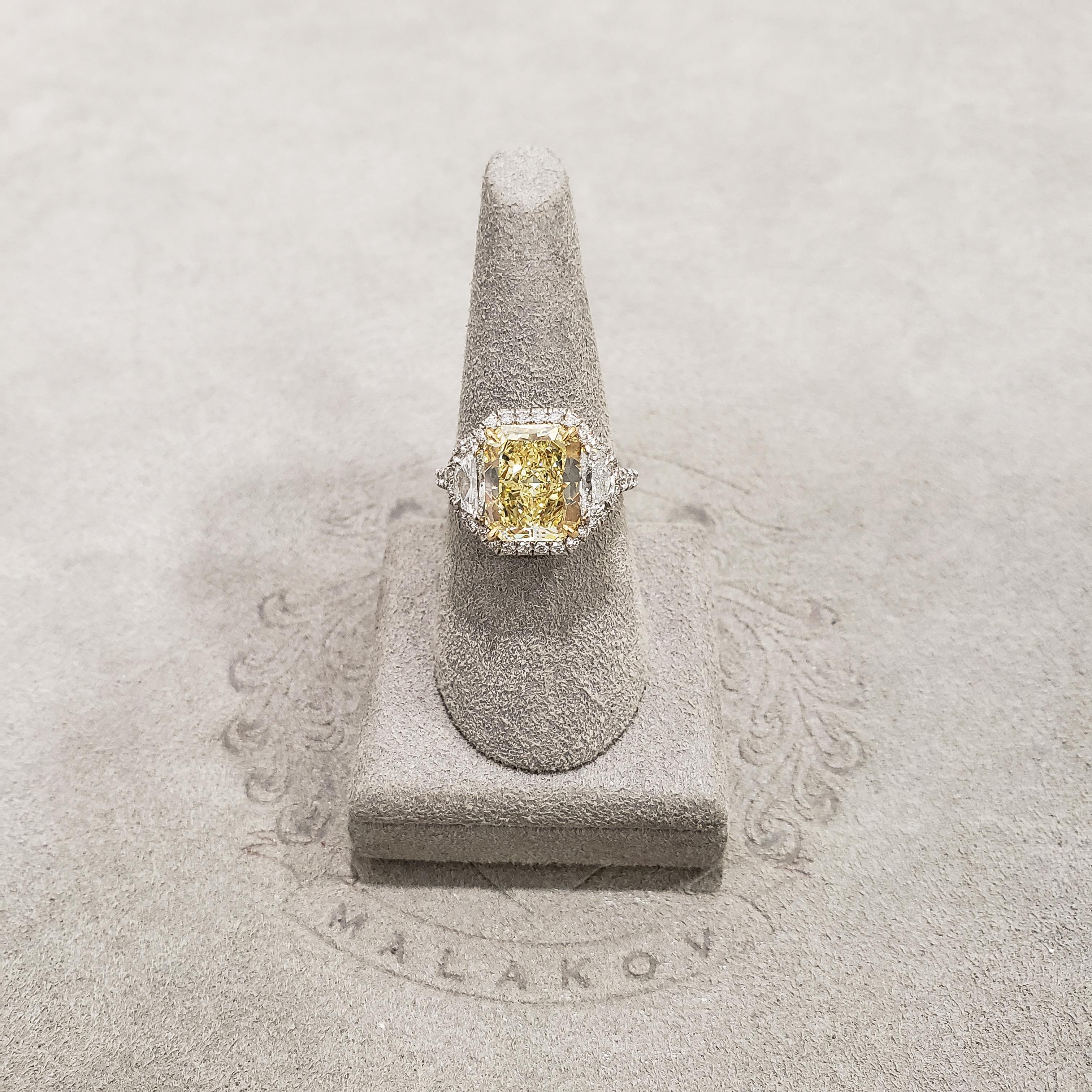 Showcasing a 3.64 carat radiant cut yellow diamond, flanked by half moon diamonds weighing 0.68 carats total. Set in an everlasting platinum mounting accented with round brilliant diamonds. GIA certified the center diamond as Fancy Yellow Color, VS2