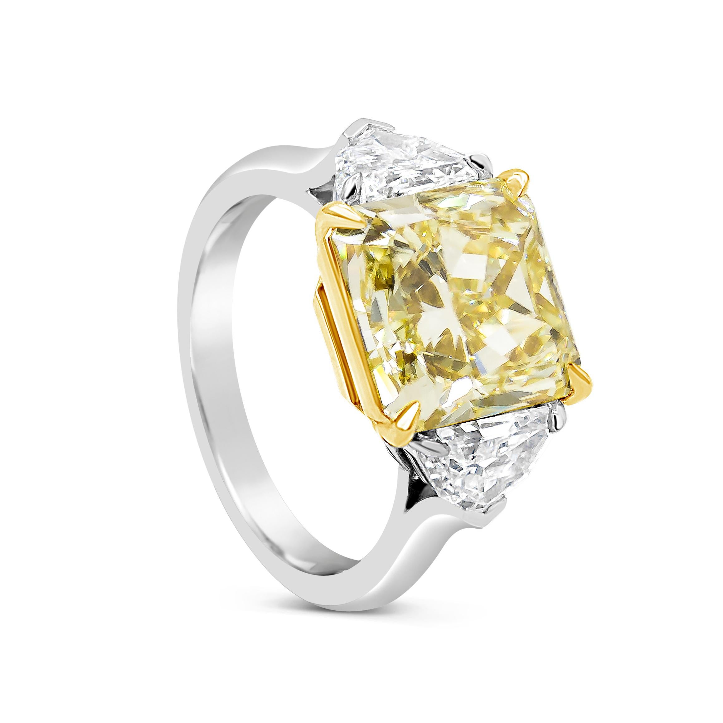 Showcasing a 3.64 carat radiant cut yellow diamond, flanked by half moon diamonds weighing 0.68 carats total. Set in an everlasting platinum mounting accented with round brilliant diamonds. GIA certified the center diamond as Fancy Yellow Color, VS2