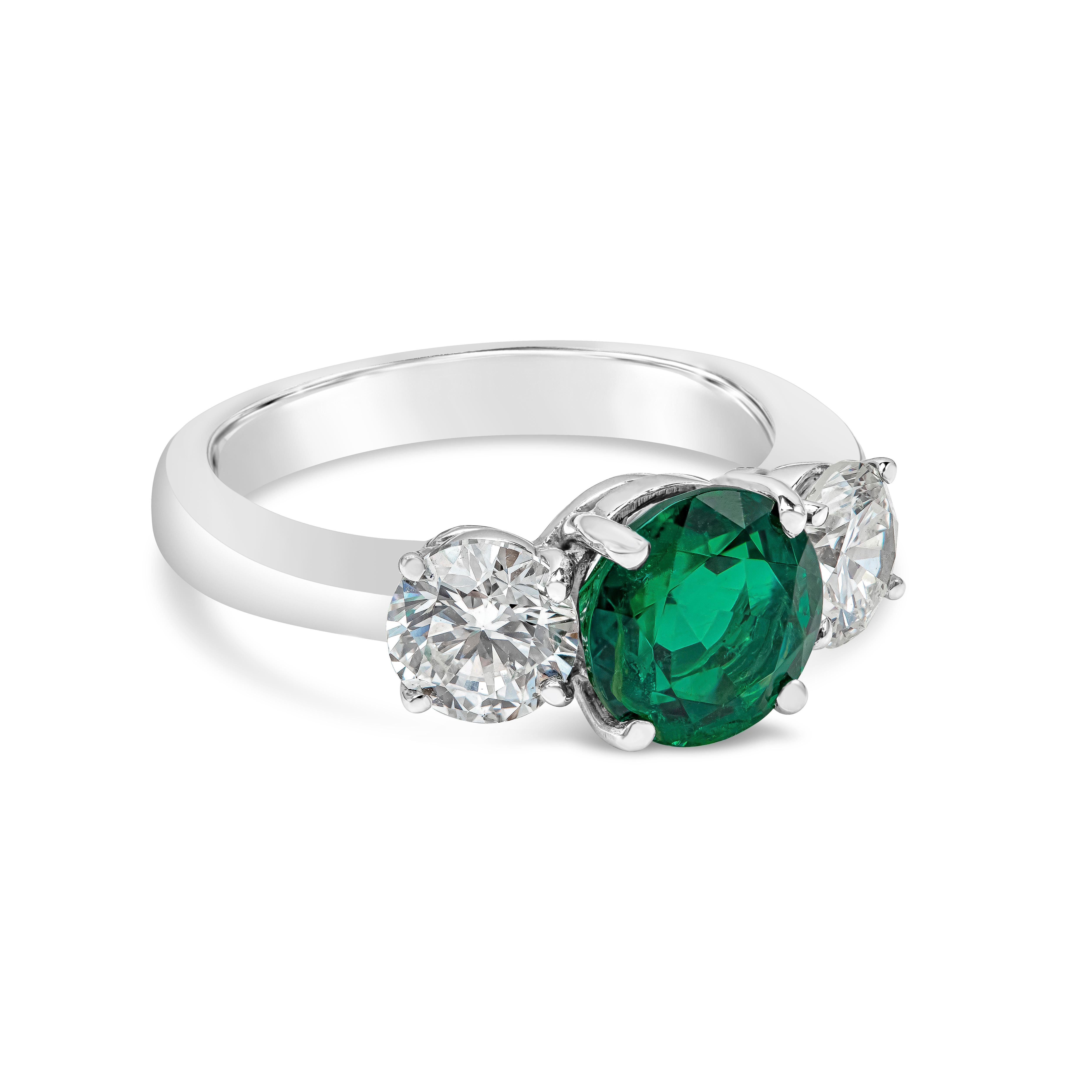 Une élégante bague de fiançailles à trois pierres, mettant en valeur une vibrante émeraude verte de 1,87 carats à taille ronde, certifiée par le GIA comme étant d'origine russe. Flanquée de deux diamants ronds de taille brillant pesant 1,30 carat au