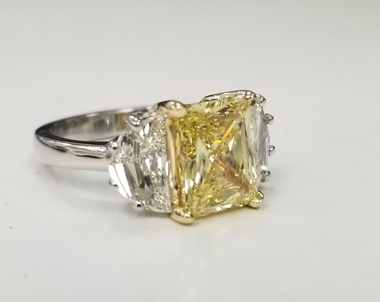  Specifications:
    main stone: GIA Certified Rectangular FANCY INTENSE YELLOW 2.79 CARAT
    DIAMONDS: 2 Half Moons 1.04cts. Color F VS
    carat total weight: 2.79 CARAT TOTAL WEIGHT
    color: FANCY INTENSE YELLOW 
    metal: Platinum and 18k