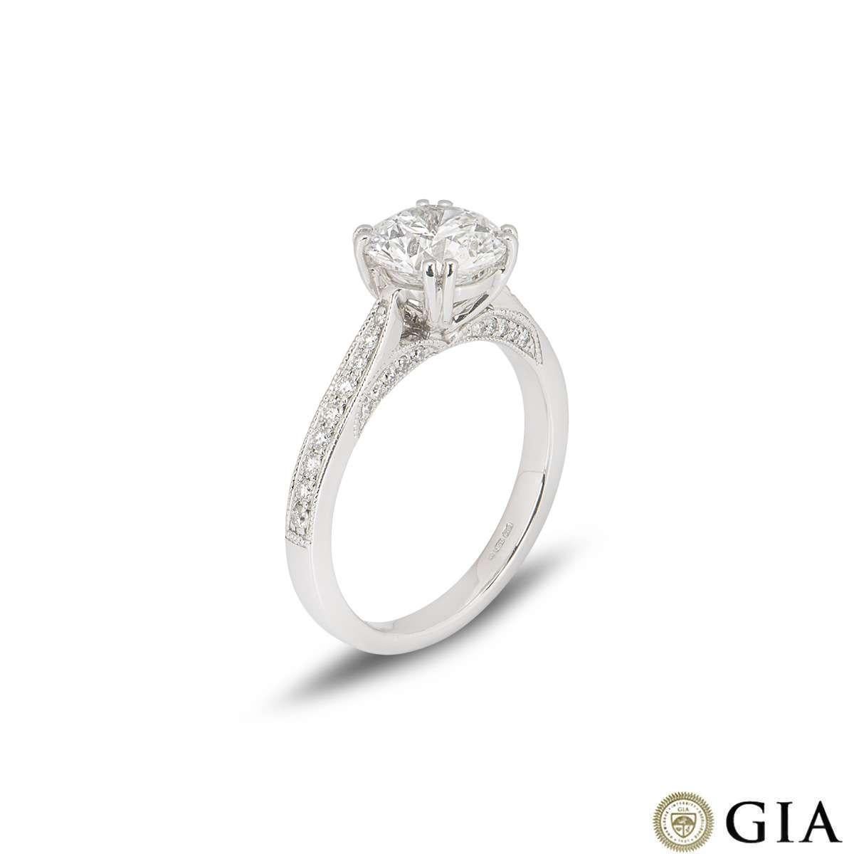 An 18k white gold diamond engagement ring. The round brilliant cut diamond weighs 1.70ct, is F in colour and VS1 in clarity. The diamond is set within a diamond set tapered mount with a modern double claw setting. The ring is currently a size UK L,