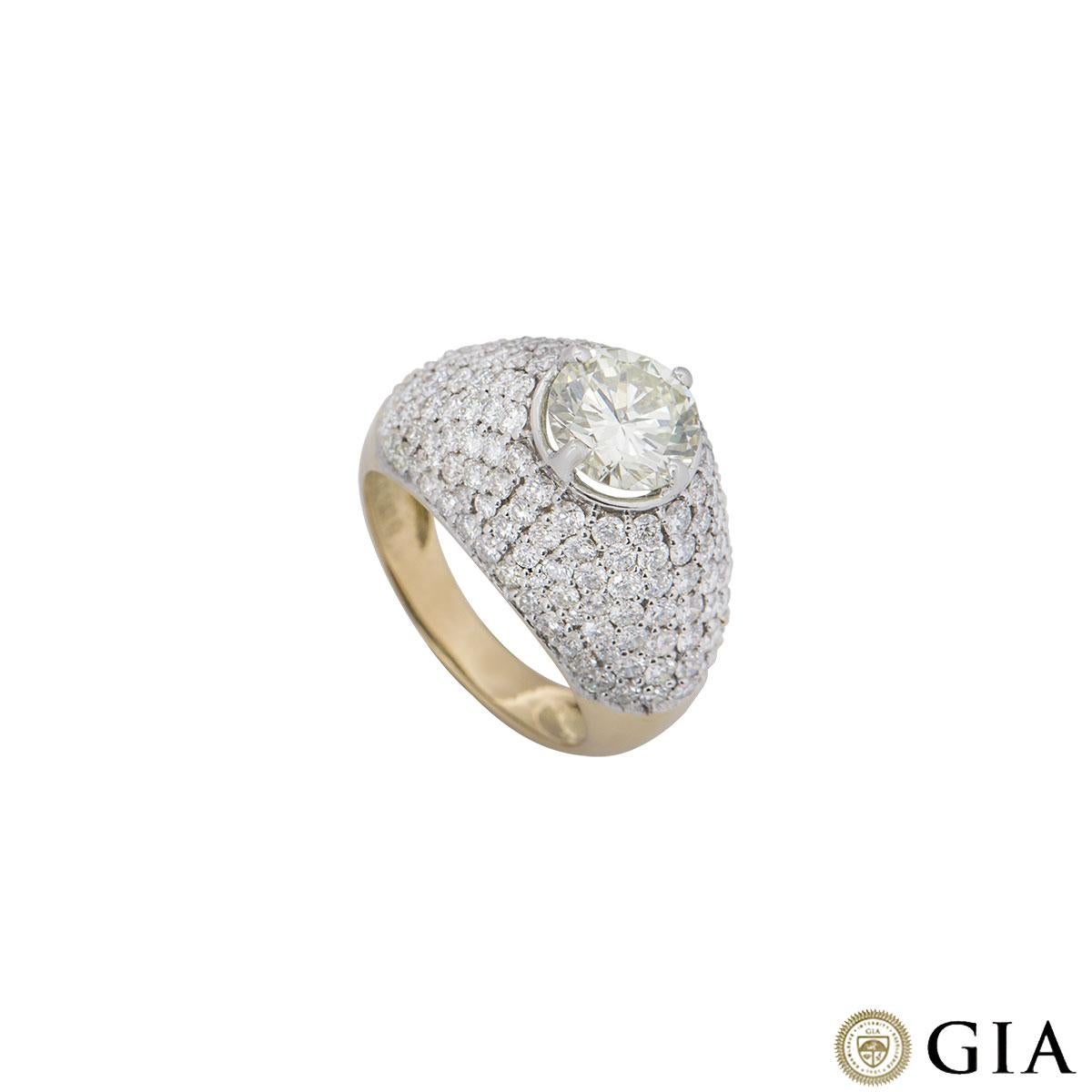 An 18k yellow gold diamond bombe ring. The ring is set to the centre with a 1.67ct round brilliant cut diamond, O to P range in colour and VVS2 clarity in a four claw setting. The diamond is accentuated by a bombe style pave set diamond border