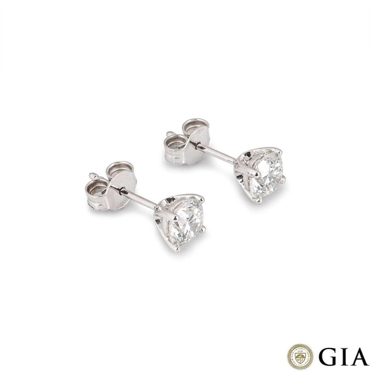 A pair of 18k white gold diamond stud earrings. The earrings feature round brilliant cut diamonds in a 4 claw setting. Both diamonds weigh 0.80ct each, one is G colour VS1 clarity and the other is H colour VS2 clarity. The earrings have post and