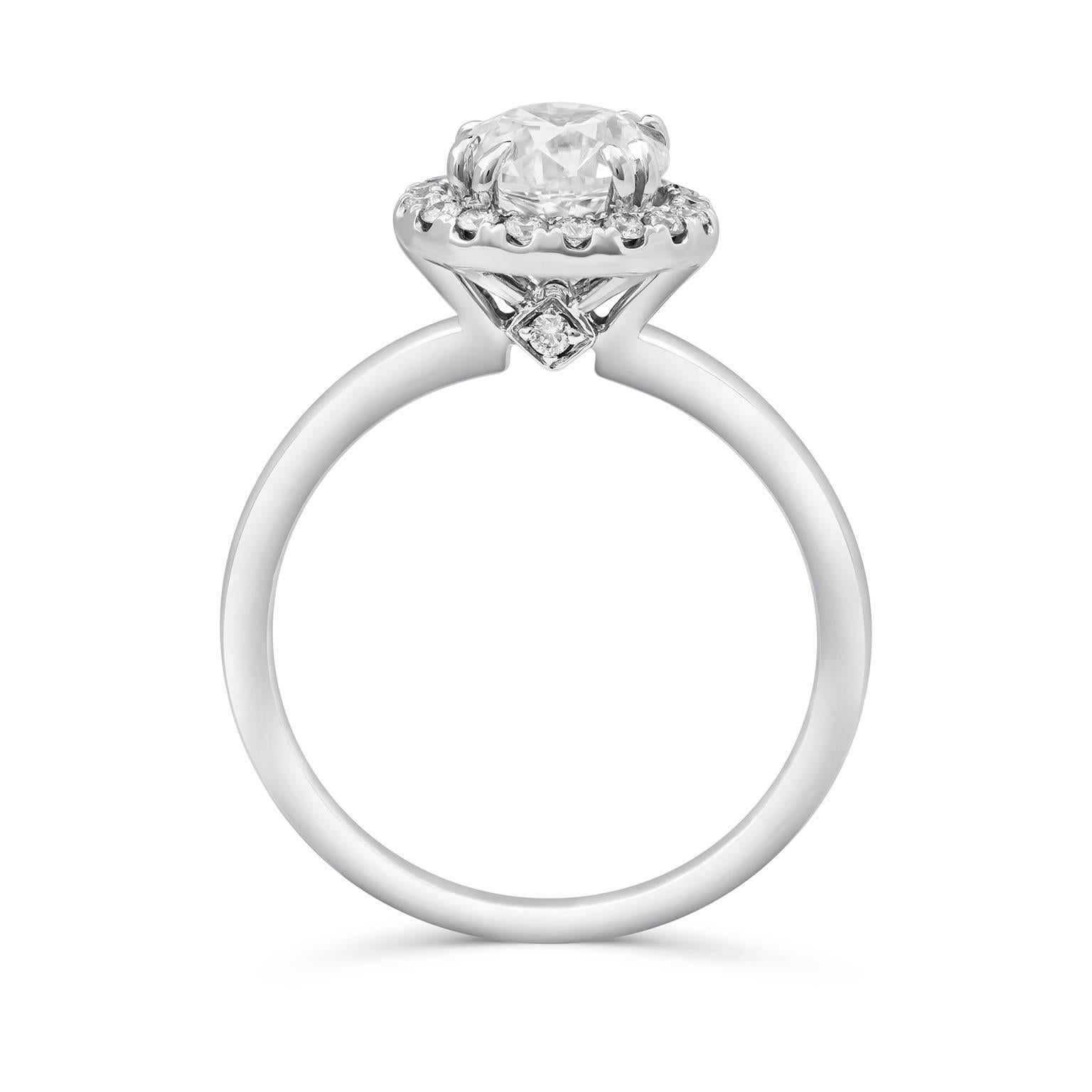 AA classic and timeless engagement ring style showcasing a 1.20 carats round diamond that GIA certified as D color, SI2 in clarity. Set in a seamless eight prong halo design accented with 0.20 carats of brilliant round diamonds. Finely made in 18K